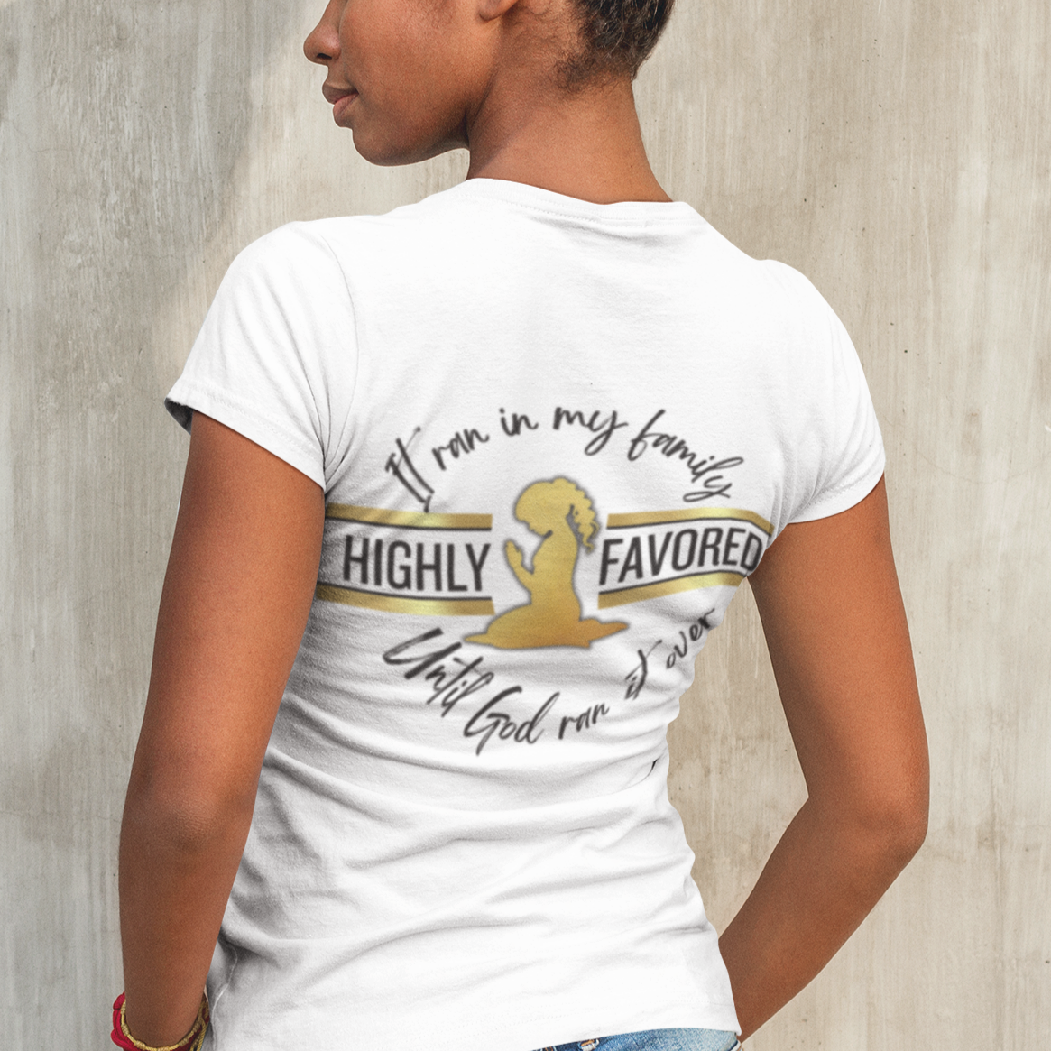 Person wearing a white t-shirt with text and a gold graphic on a textured wall background