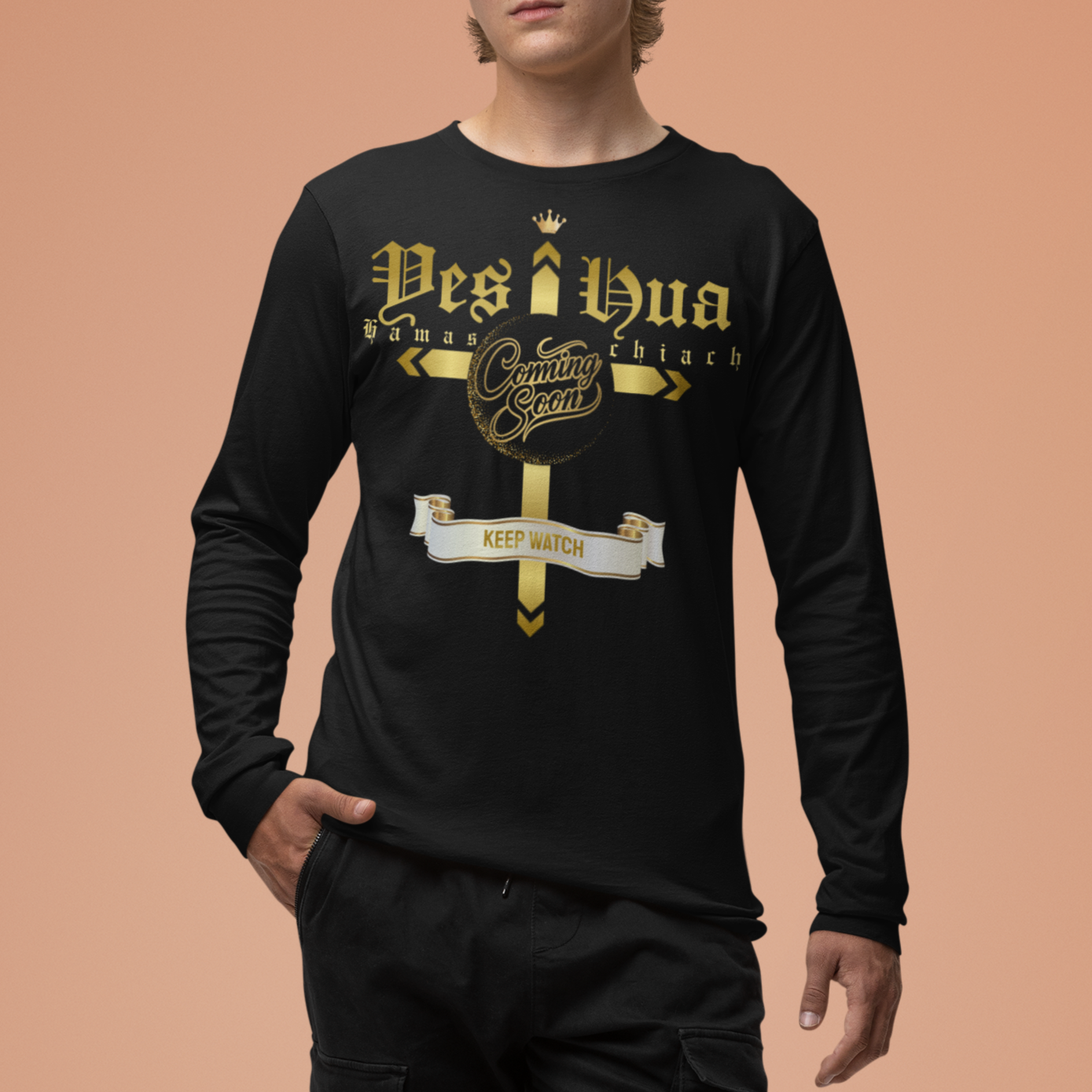 Person wearing a black long-sleeve shirt with gold text and black pants on a peach background