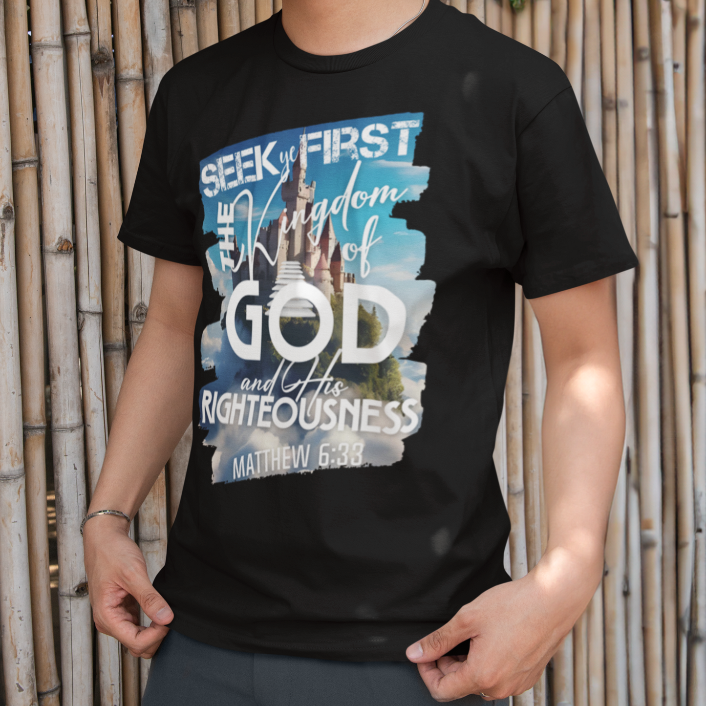 Person wearing a black t-shirt with a graphic design in front of a bamboo wall