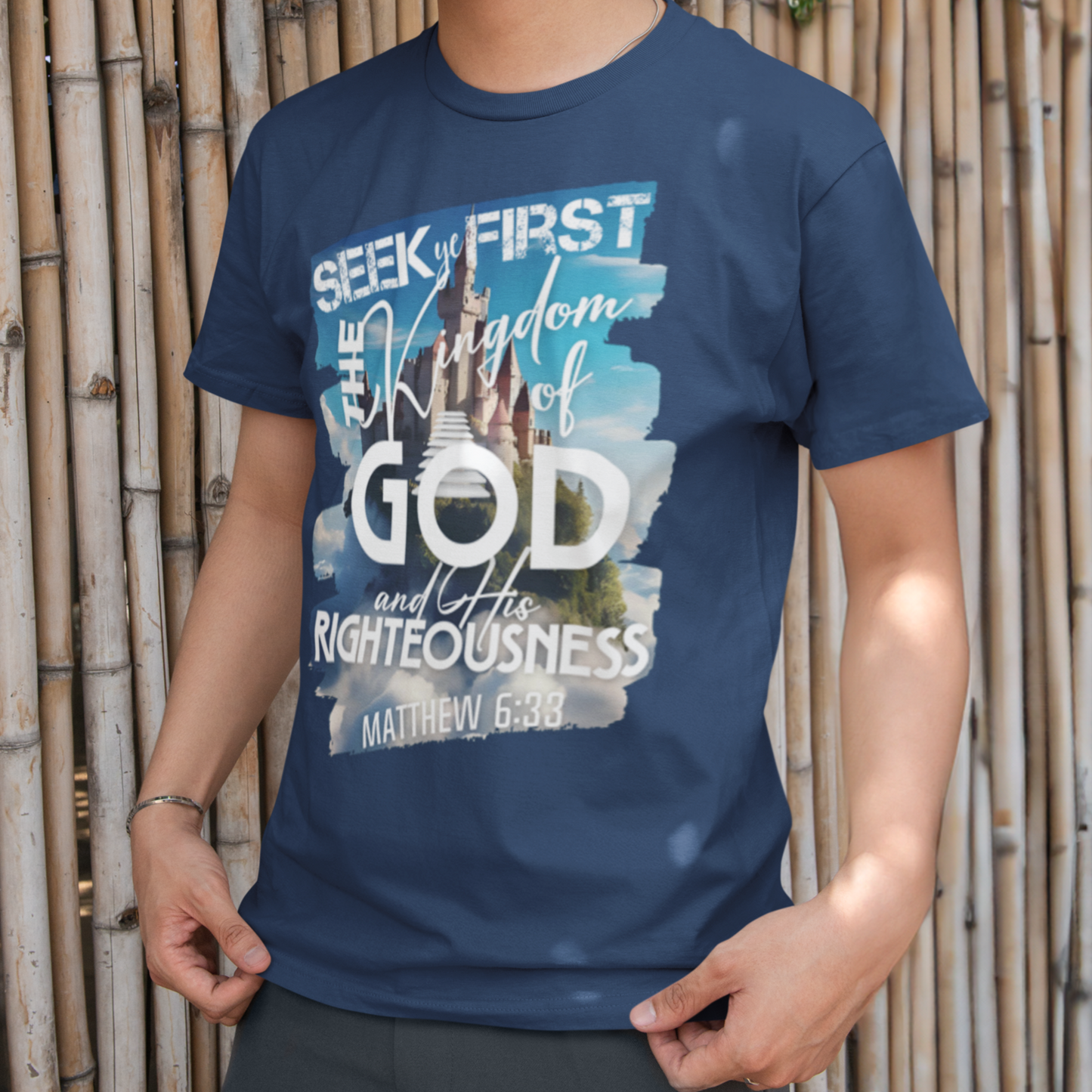 Person wearing a blue t-shirt with text standing against a bamboo wall