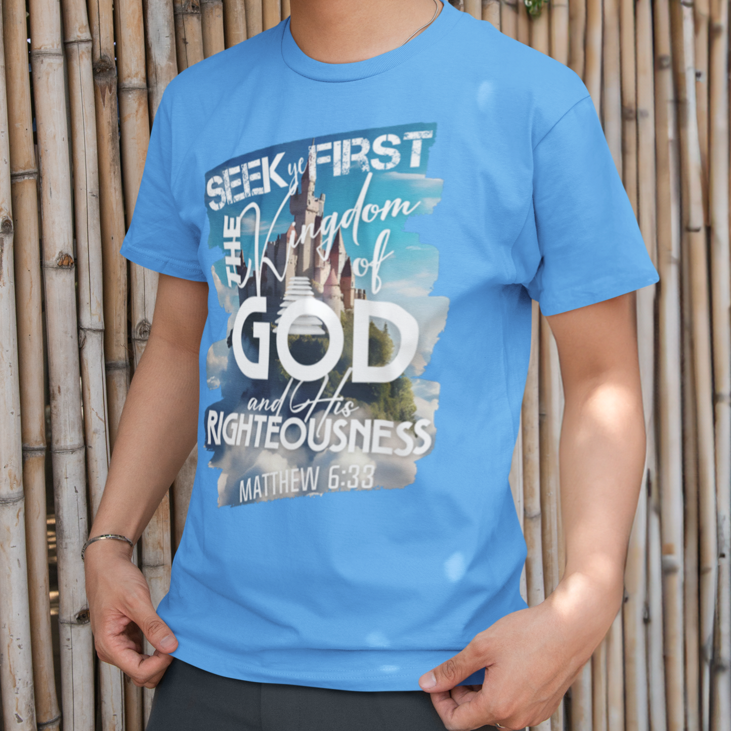 Person wearing a blue t-shirt with a graphic design in front of a bamboo wall