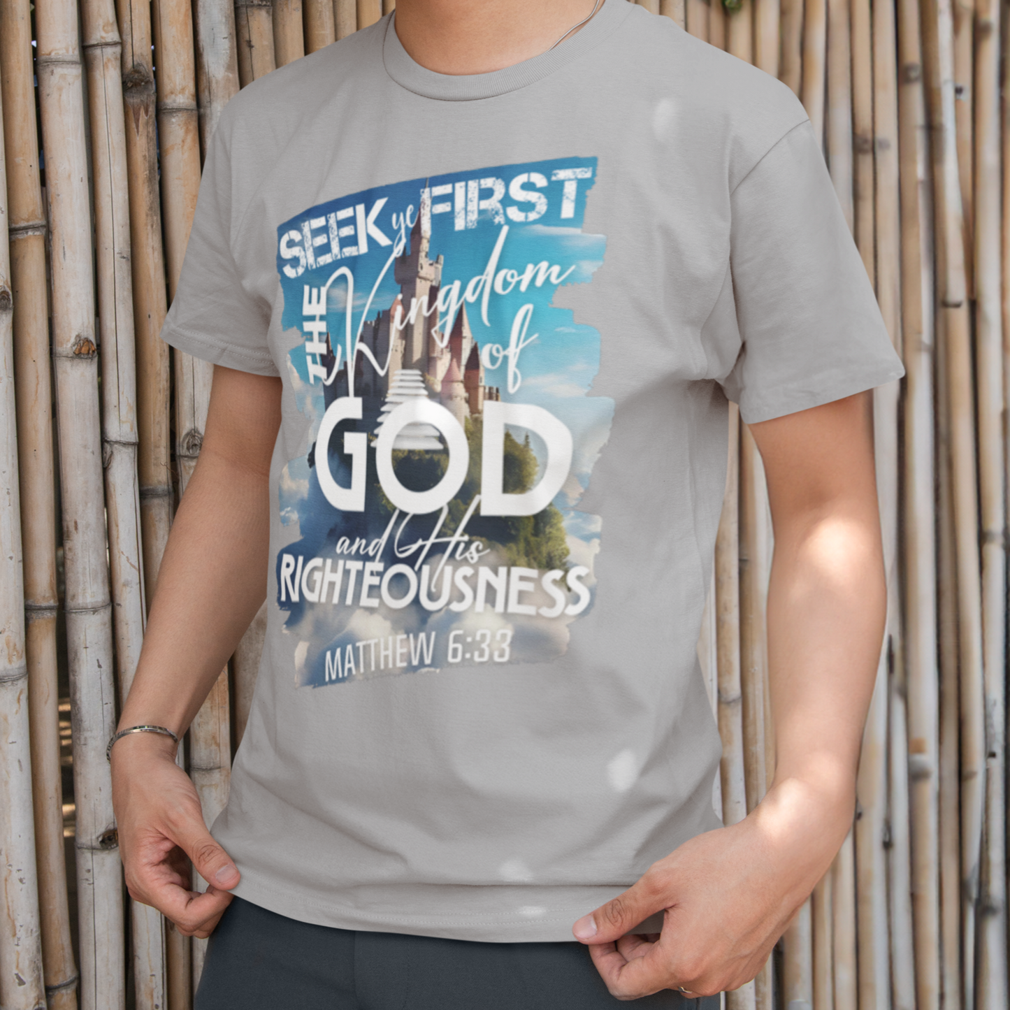 Person wearing a gray t-shirt with a motivational quote against a bamboo background