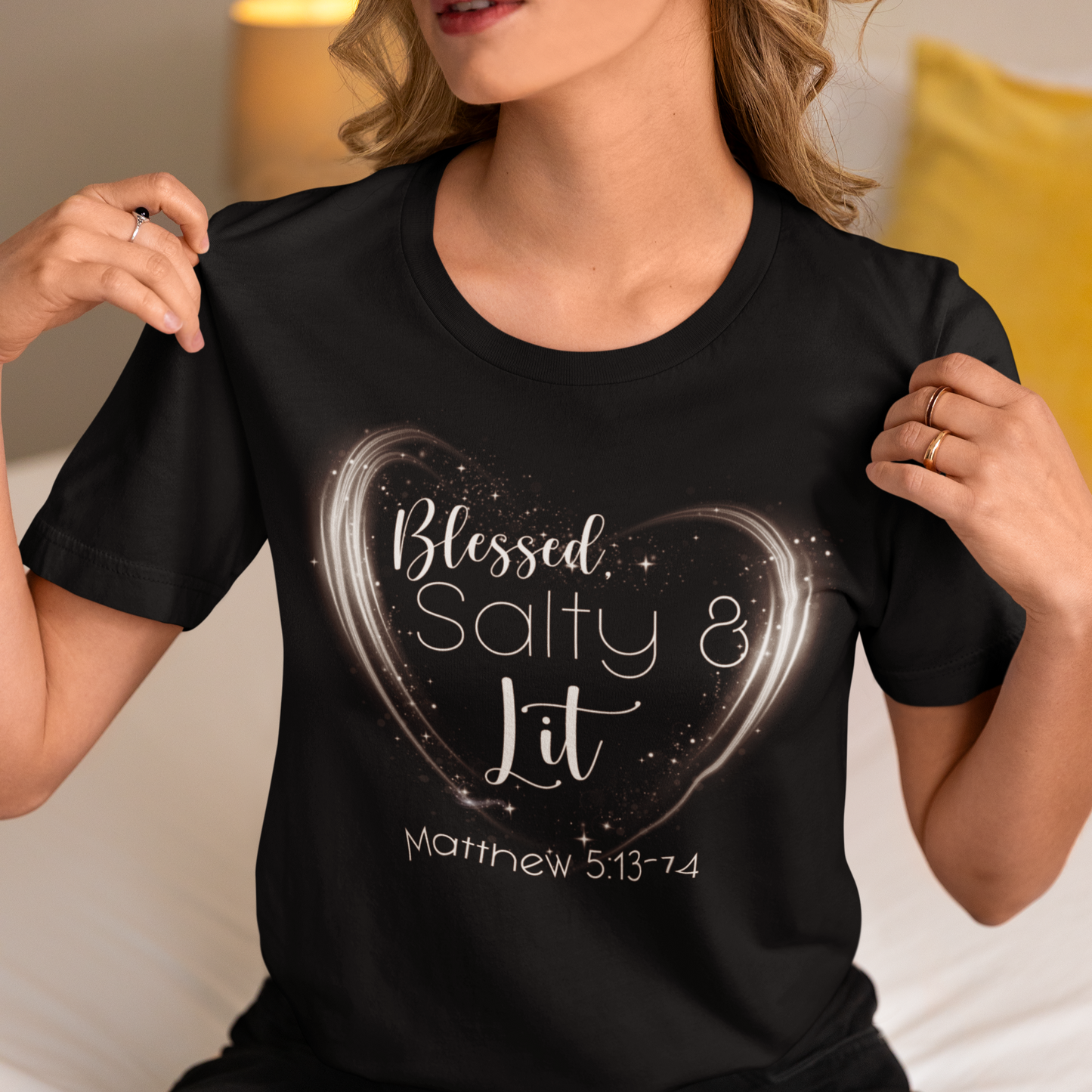 Person wearing a black t-shirt with a heart design and text.