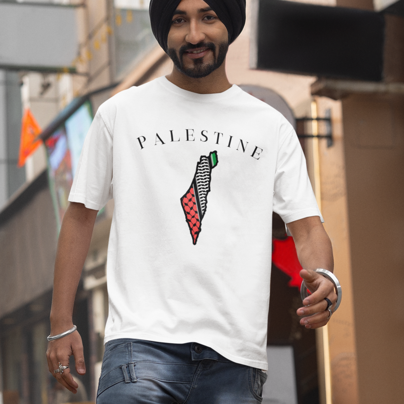 Man wearing a white t-shirt with 'Palestine' design on a city street.