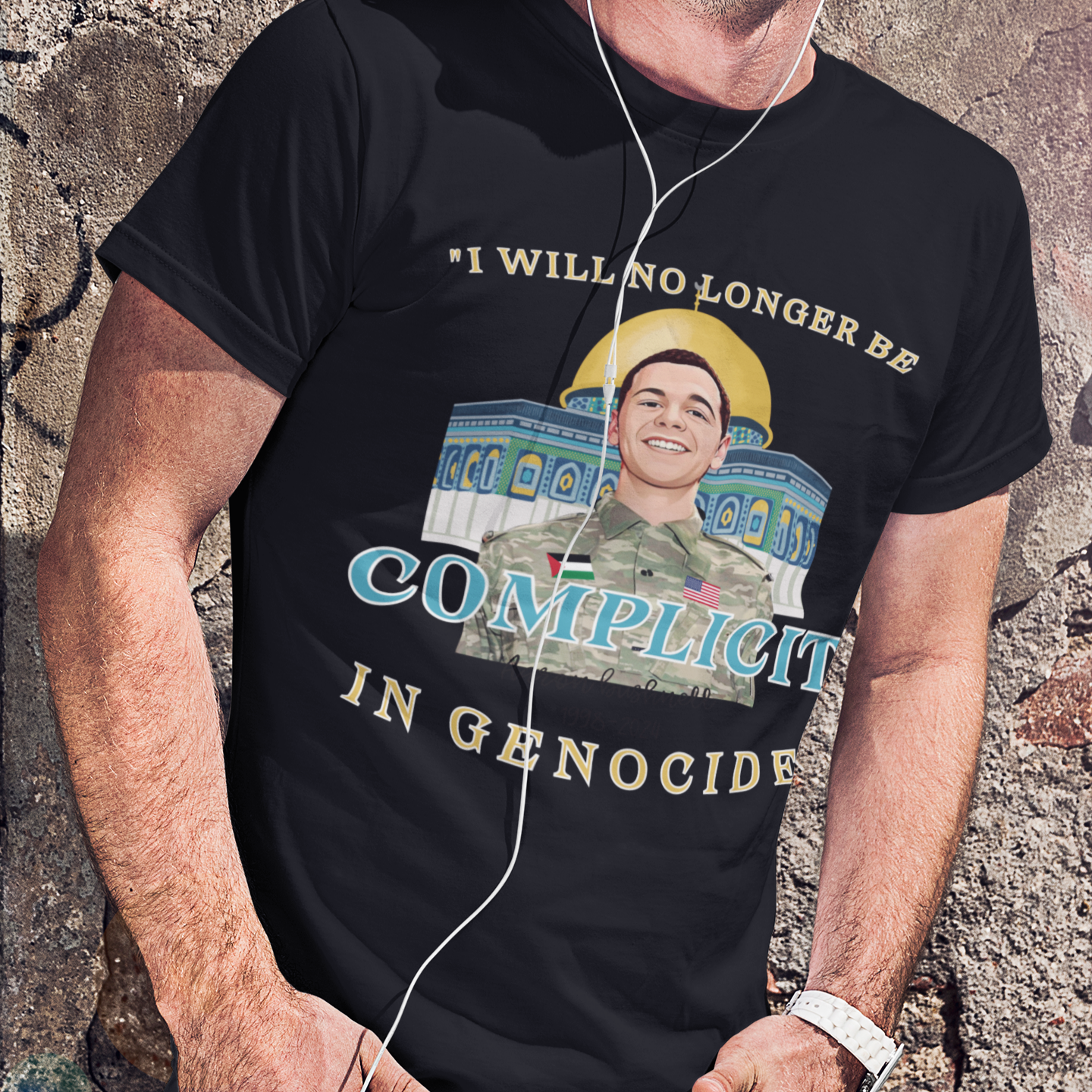 Person wearing a black t-shirt with graphic and text against a textured wall.