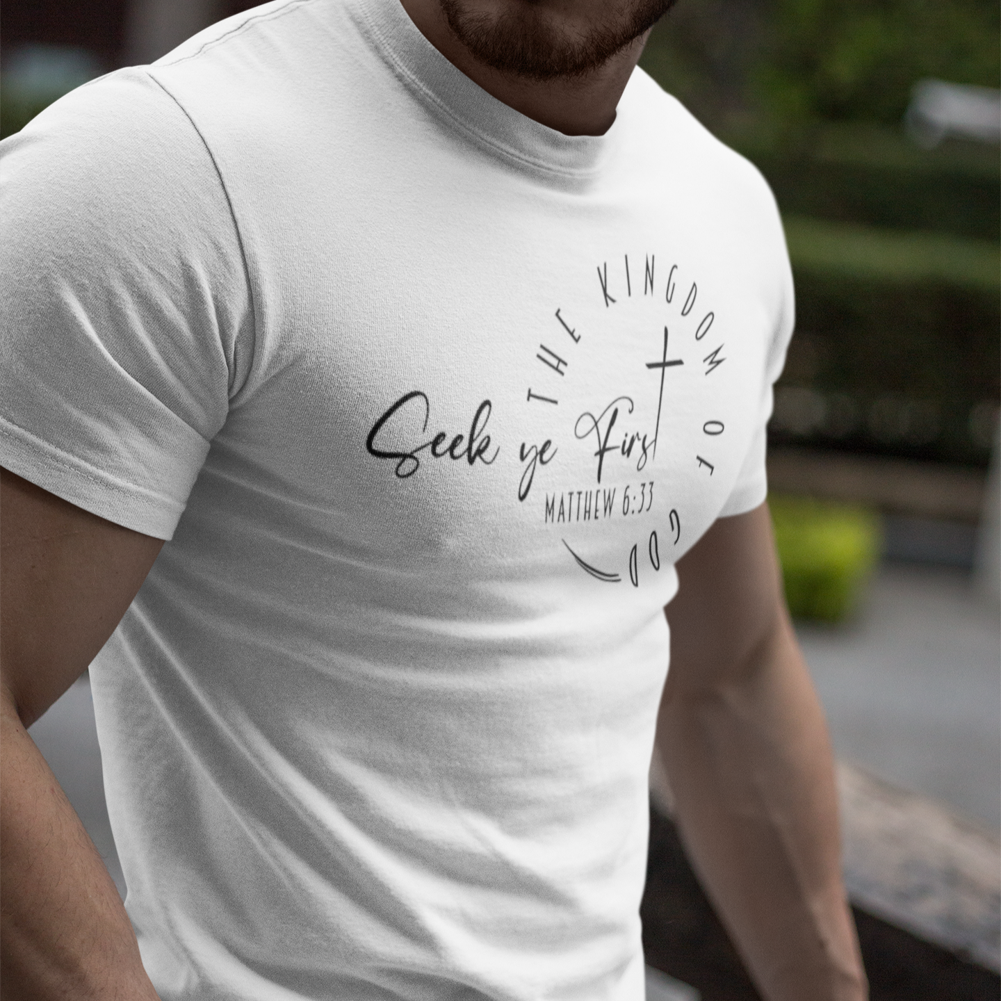 Person wearing a white t-shirt with text and design outdoors