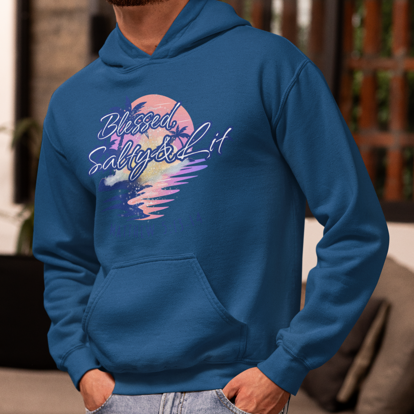 Person wearing a blue hoodie with a colorful graphic design in a living room setting