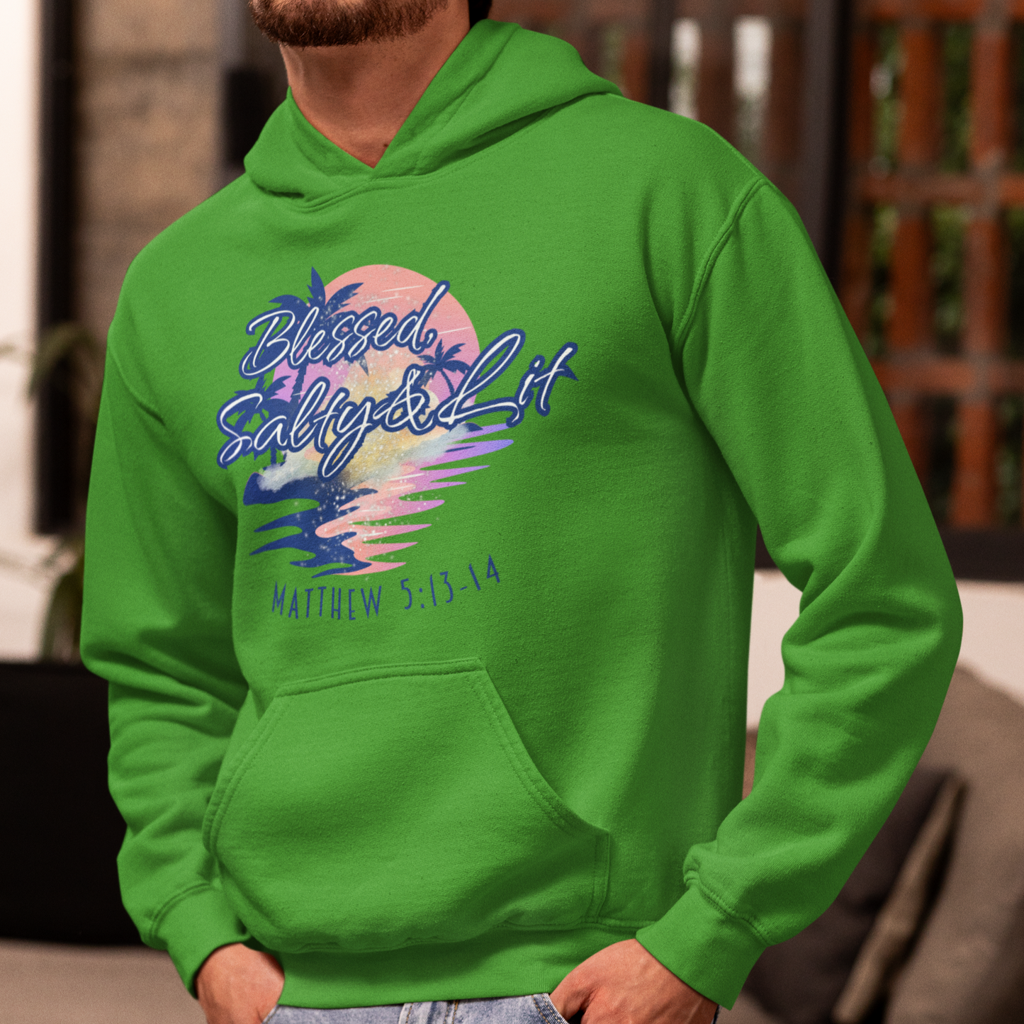 Person wearing a green hoodie with a colorful design and text, standing in a room.