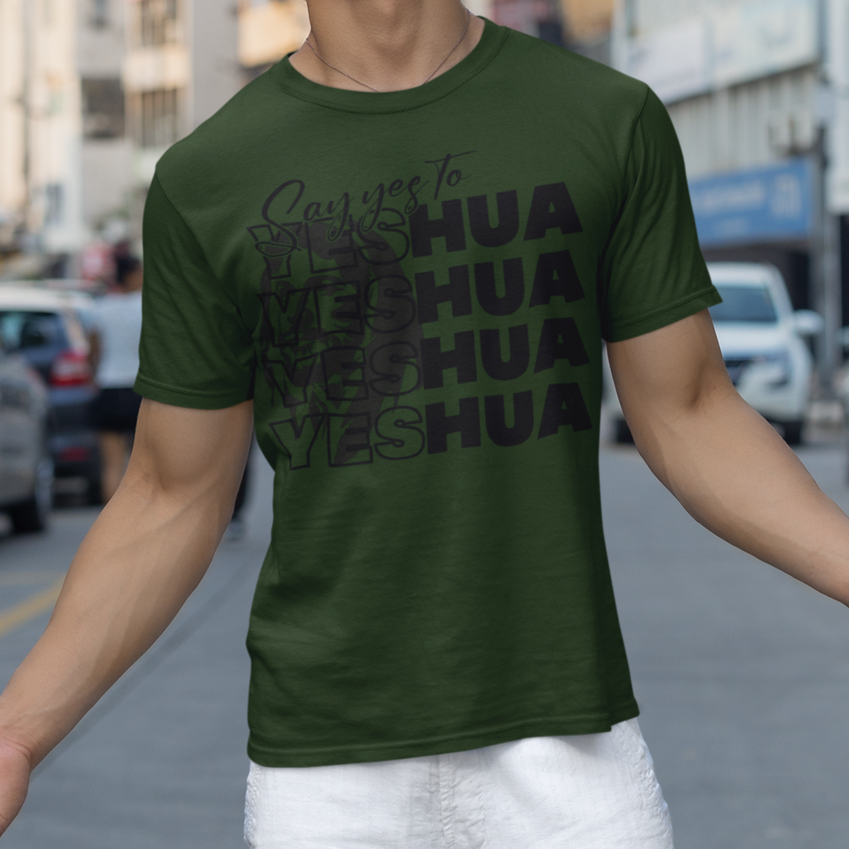 Man wearing a green t-shirt with text on a city street