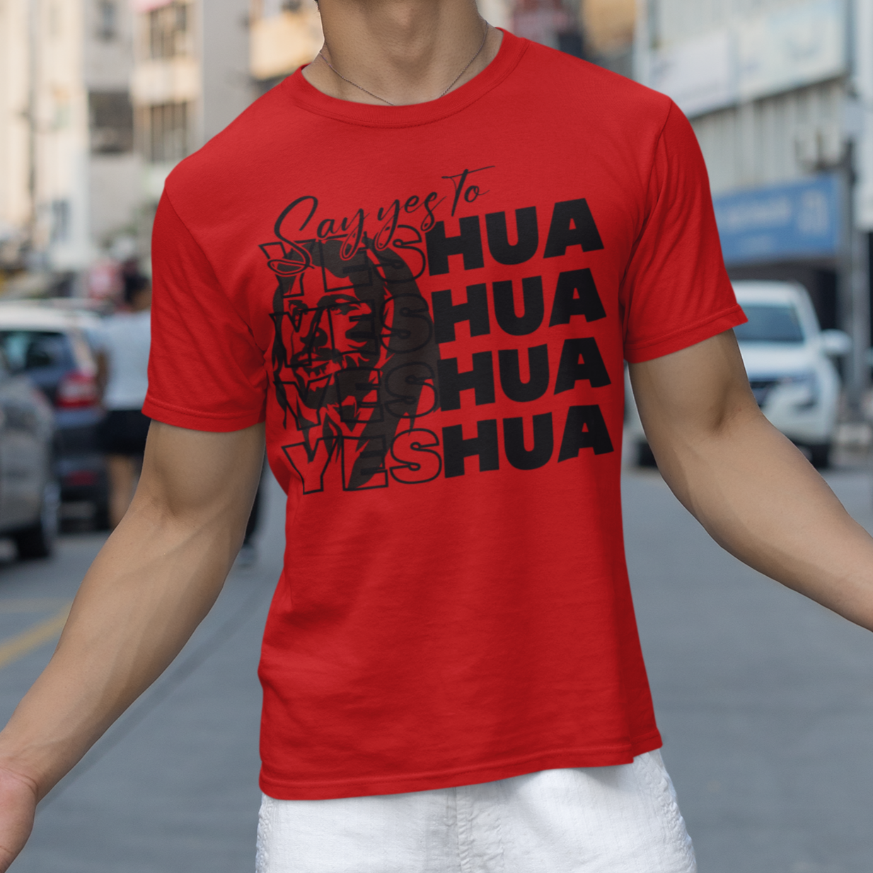 Person wearing a red t-shirt with text on a city street