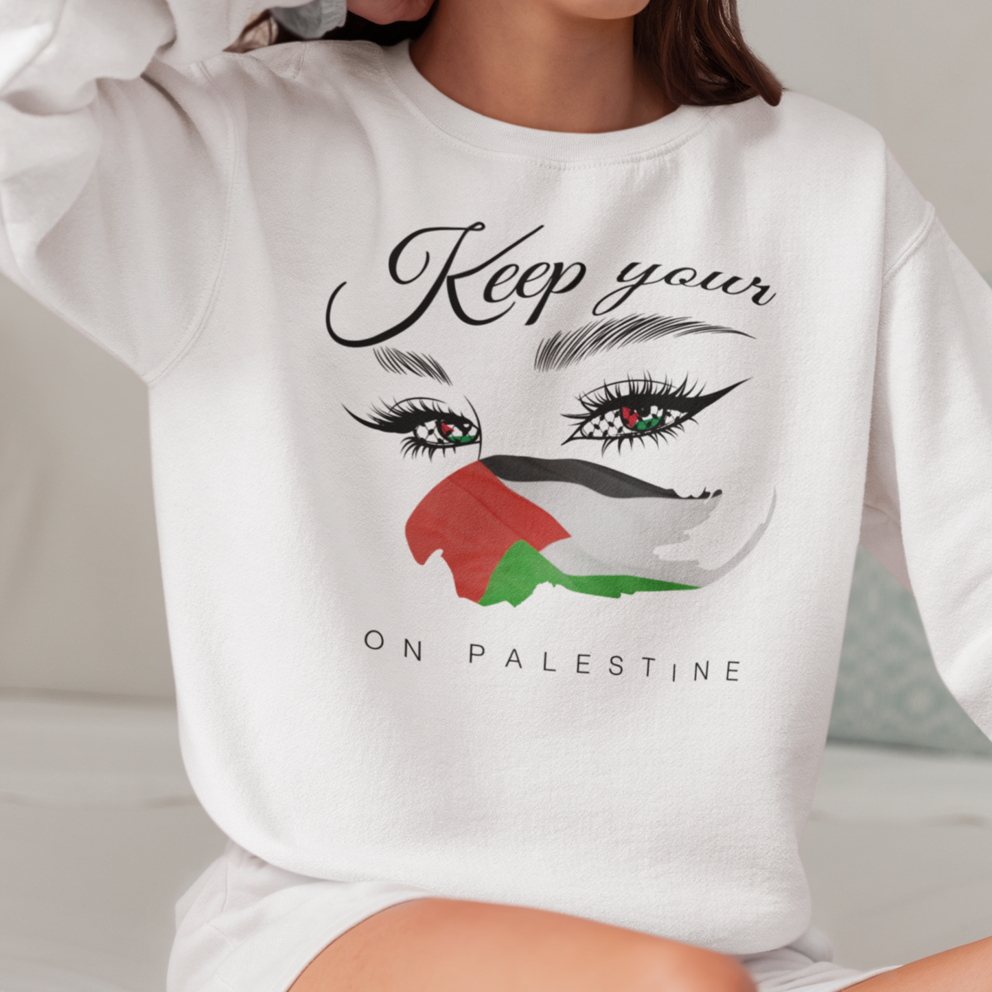 Person wearing a white sweatshirt with a graphic design and text.