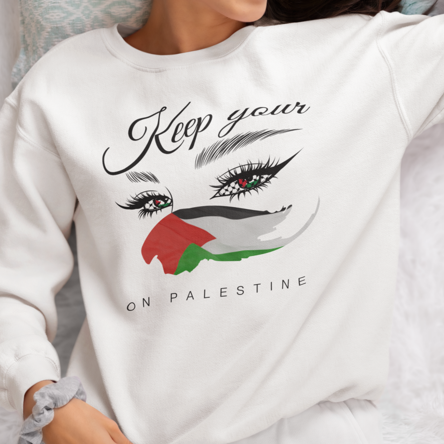 Person wearing a white sweatshirt with a design and text related to Palestine