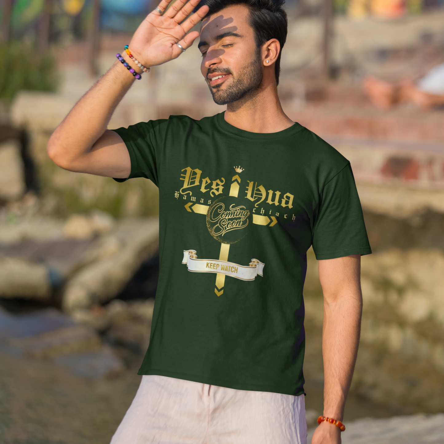 Man wearing a green t-shirt with text, standing in front of a colorful mural.