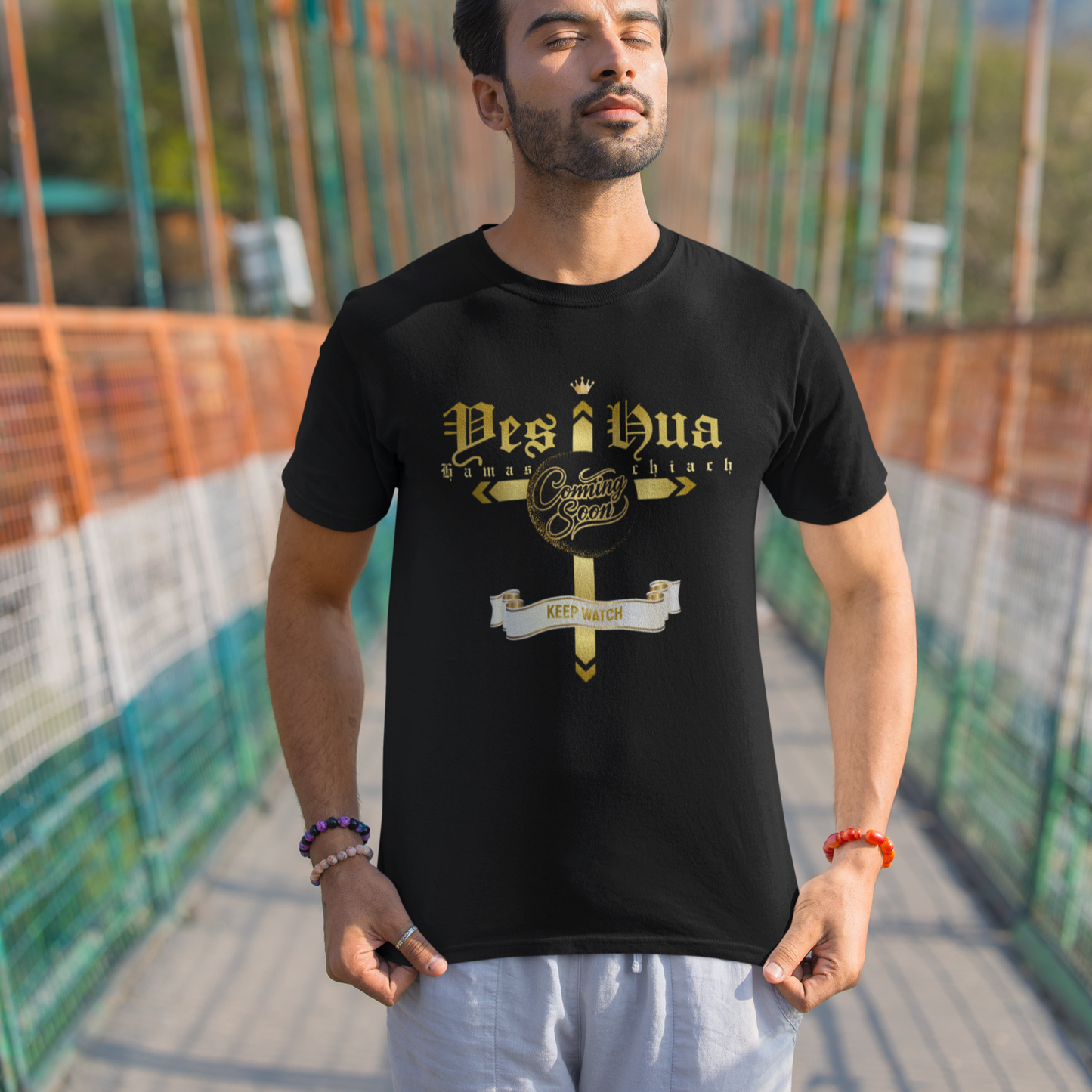Man wearing a black t-shirt with 'Desi Bua' design on a suspension bridge
