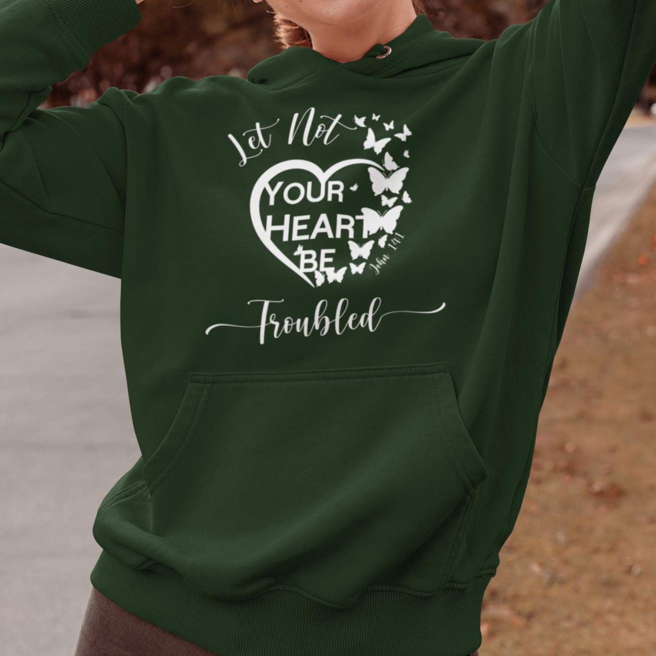 Person wearing a green hoodie with a motivational quote outdoors