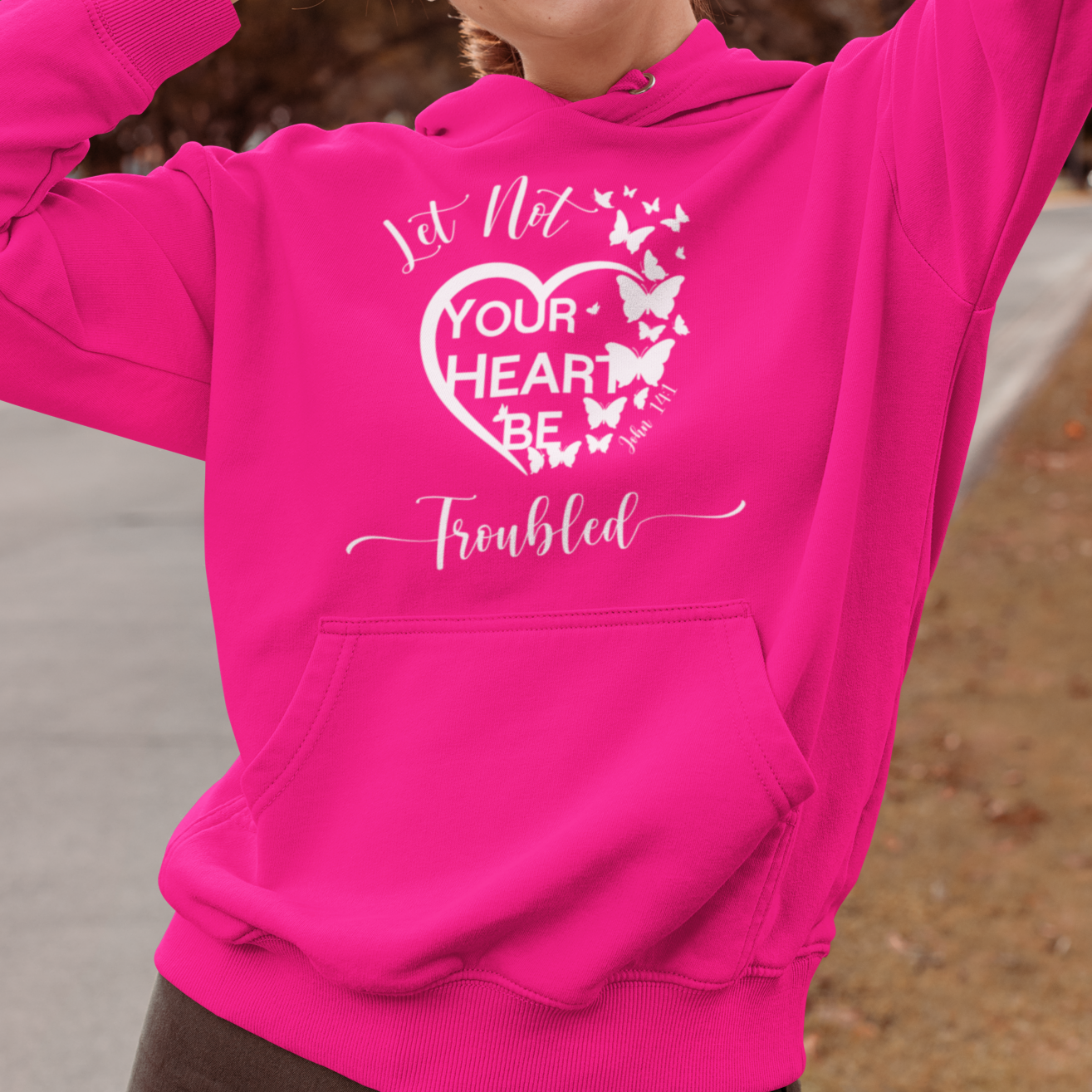 Person wearing a pink hoodie with a heart design outdoors