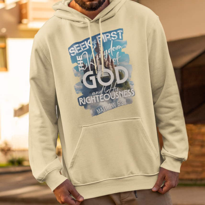 Man wearing a light-colored hoodie with text and graphics, standing on a street.