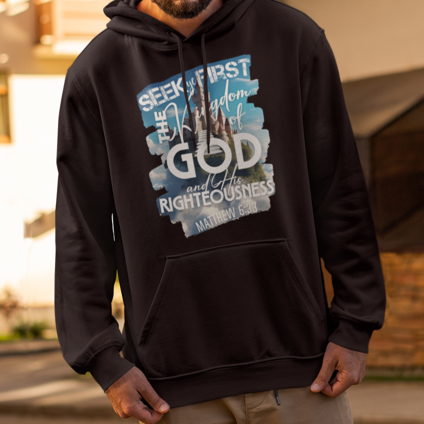 Man wearing a black hoodie with text and graphics, standing on a street.