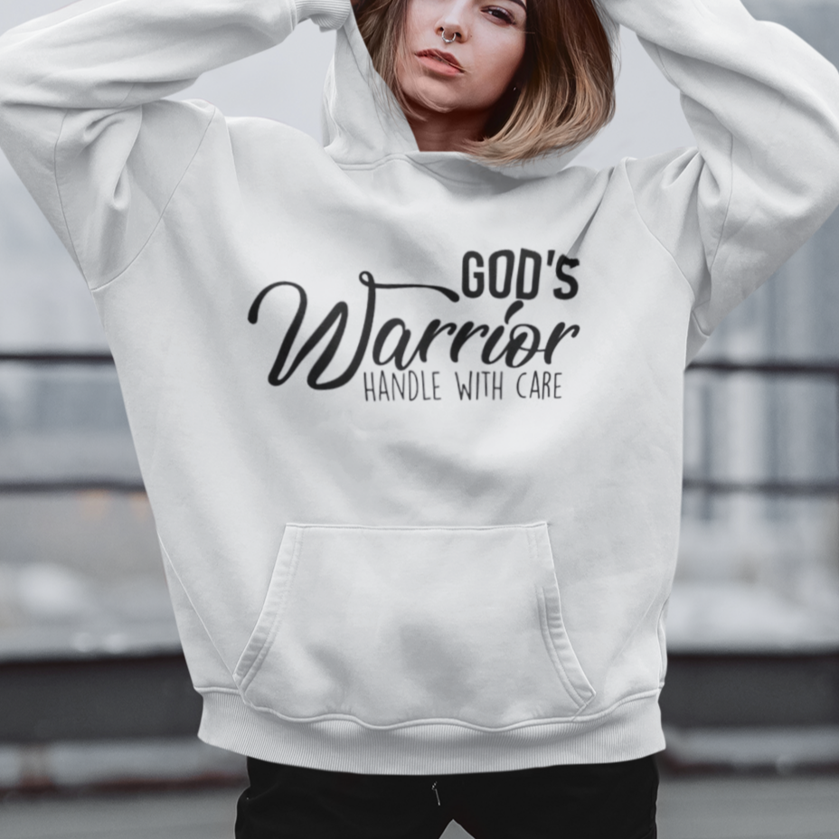 Person wearing a white hoodie with 'God's Warrior Handle with Care' text on a rooftop.