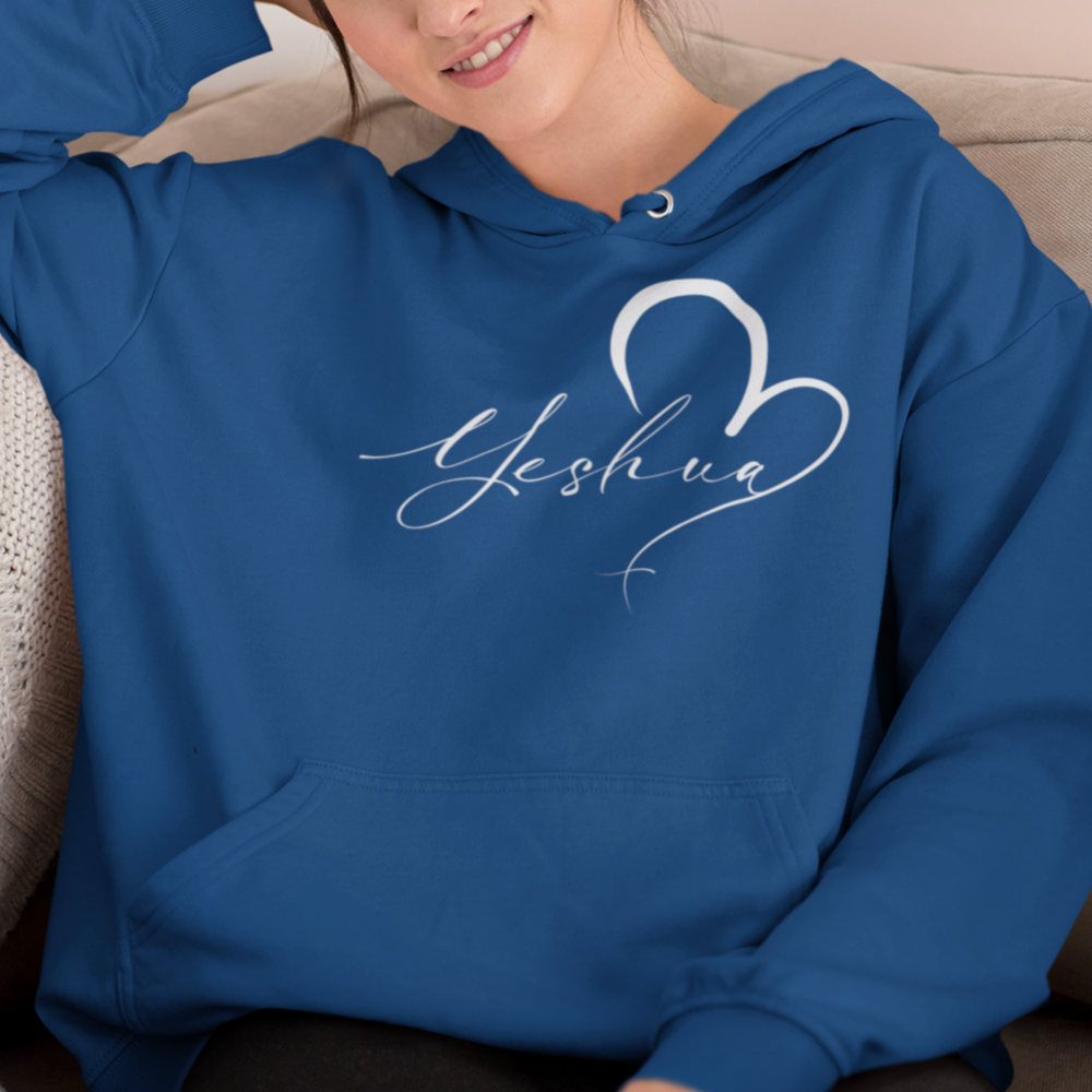 Woman wearing a blue hoodie with 'Yeshua' design sitting on a couch.