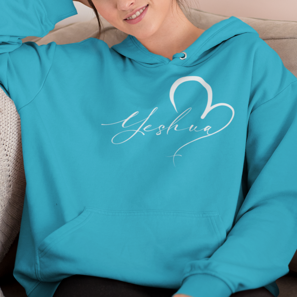 Woman wearing a turquoise hoodie with 'Yesenia' design, sitting on a couch.