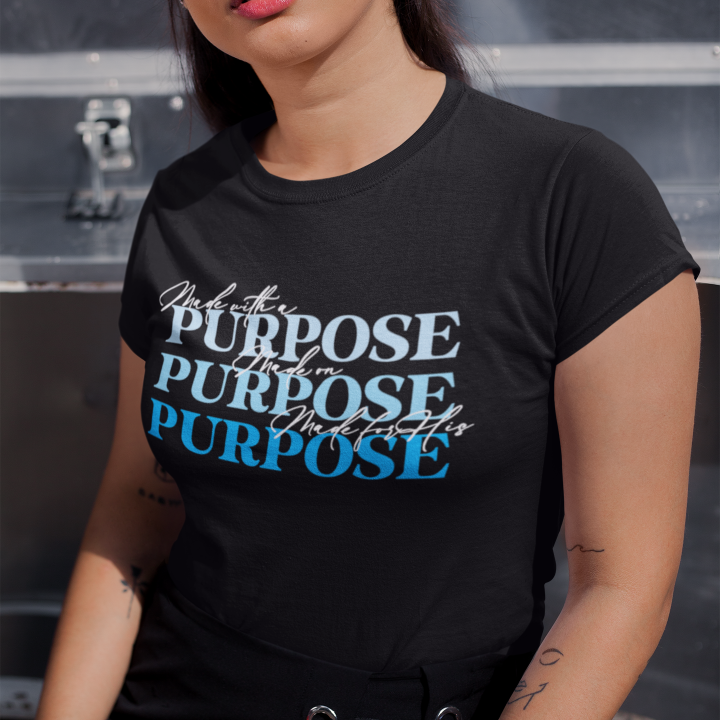Woman wearing a black t-shirt with 'Purpose' text design.