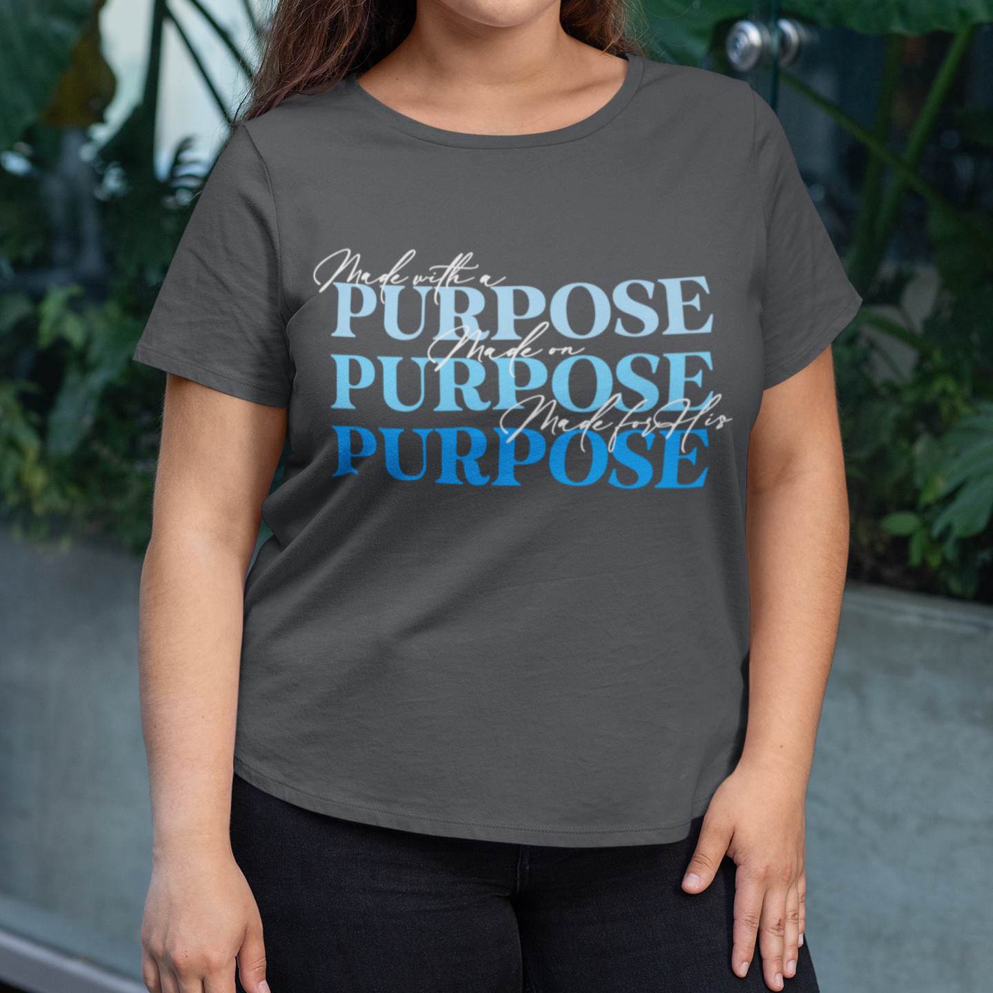 Person wearing a gray t-shirt with 'Purpose' text in different fonts and colors.