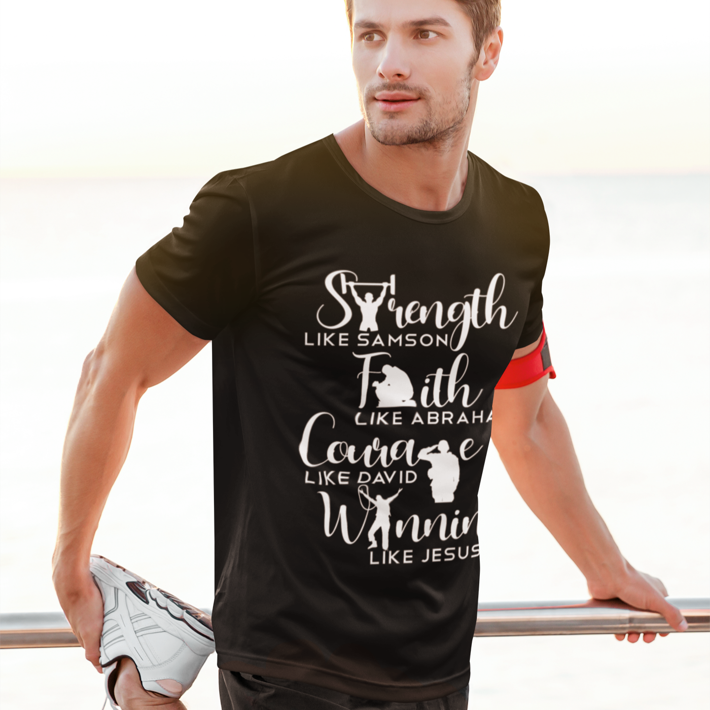 Man wearing a black t-shirt with motivational text by a body of water