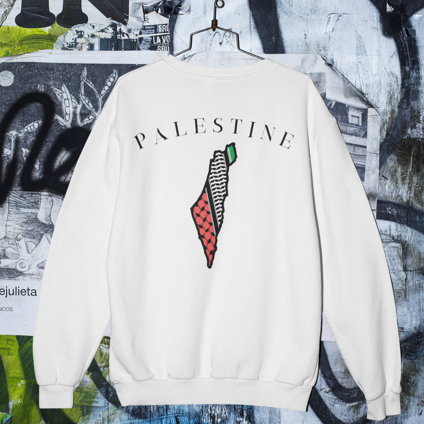 White sweatshirt with 'PALESTINE' text and design on a graffiti-covered wall background