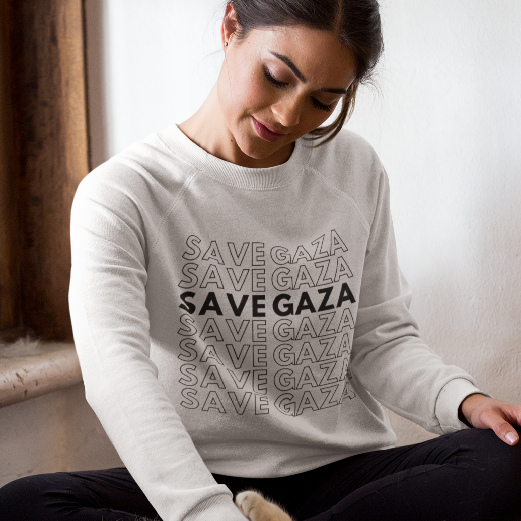 Woman wearing a 'Save Gaza' sweatshirt petting a cat indoors.