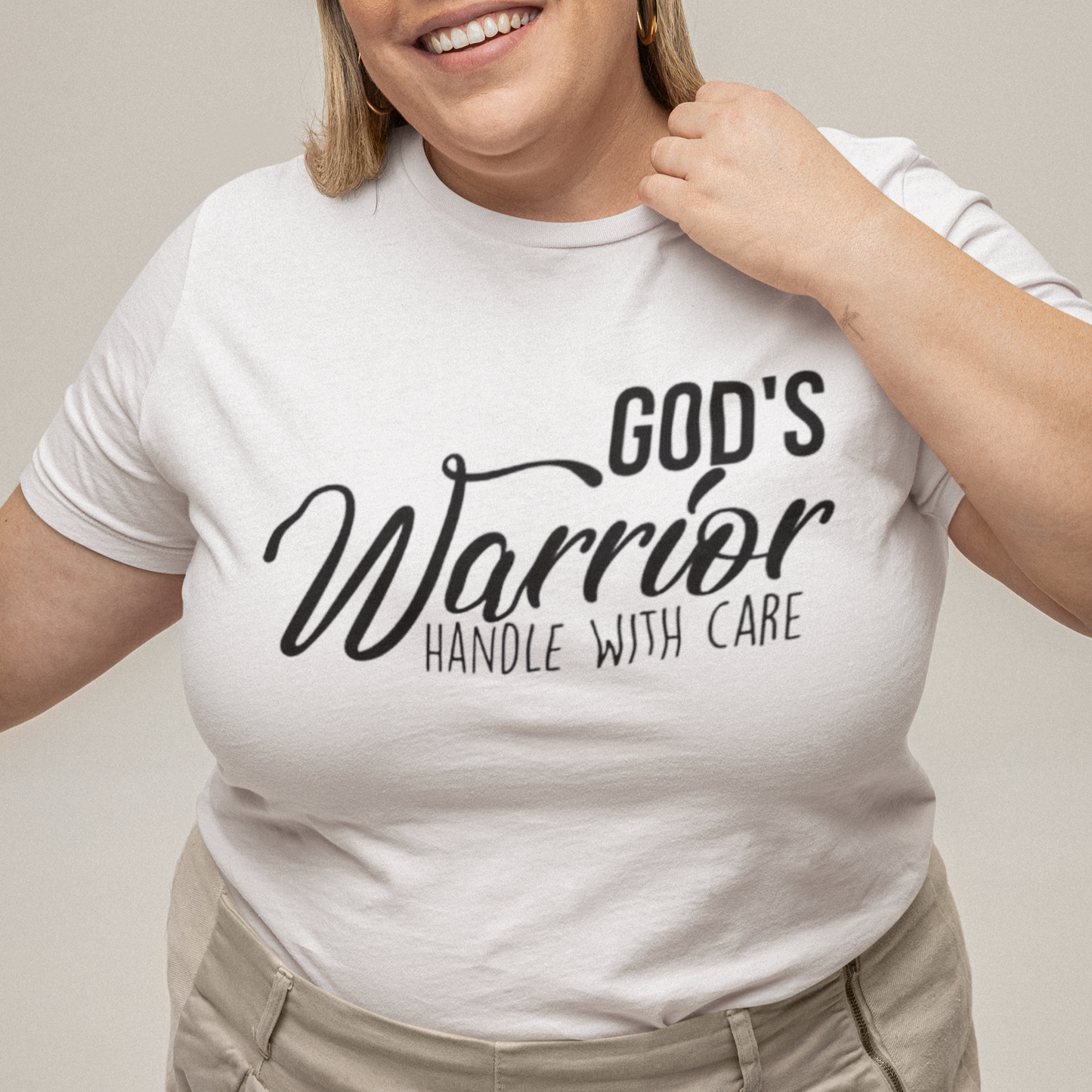Person wearing a white t-shirt with text, standing against a plain background