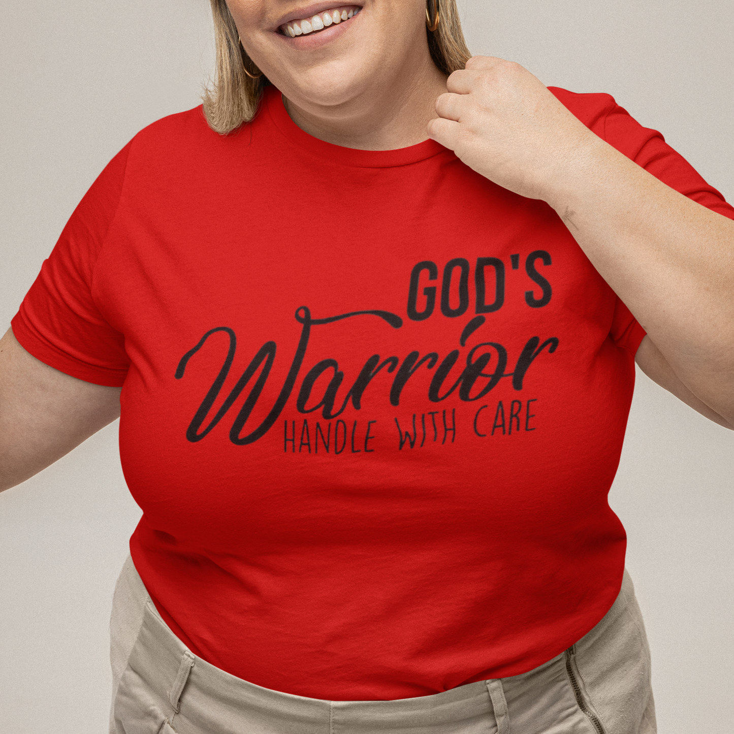 Person wearing a red t-shirt with text, standing against a plain background