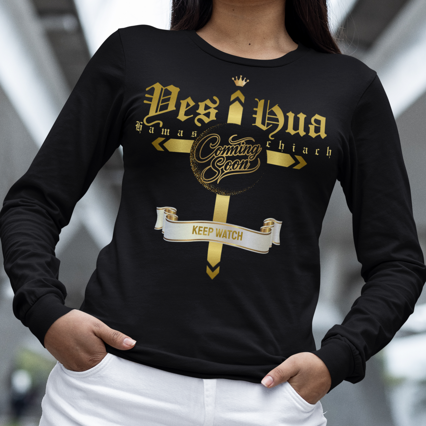 Person wearing a black long-sleeve shirt with gold and white text and graphics.