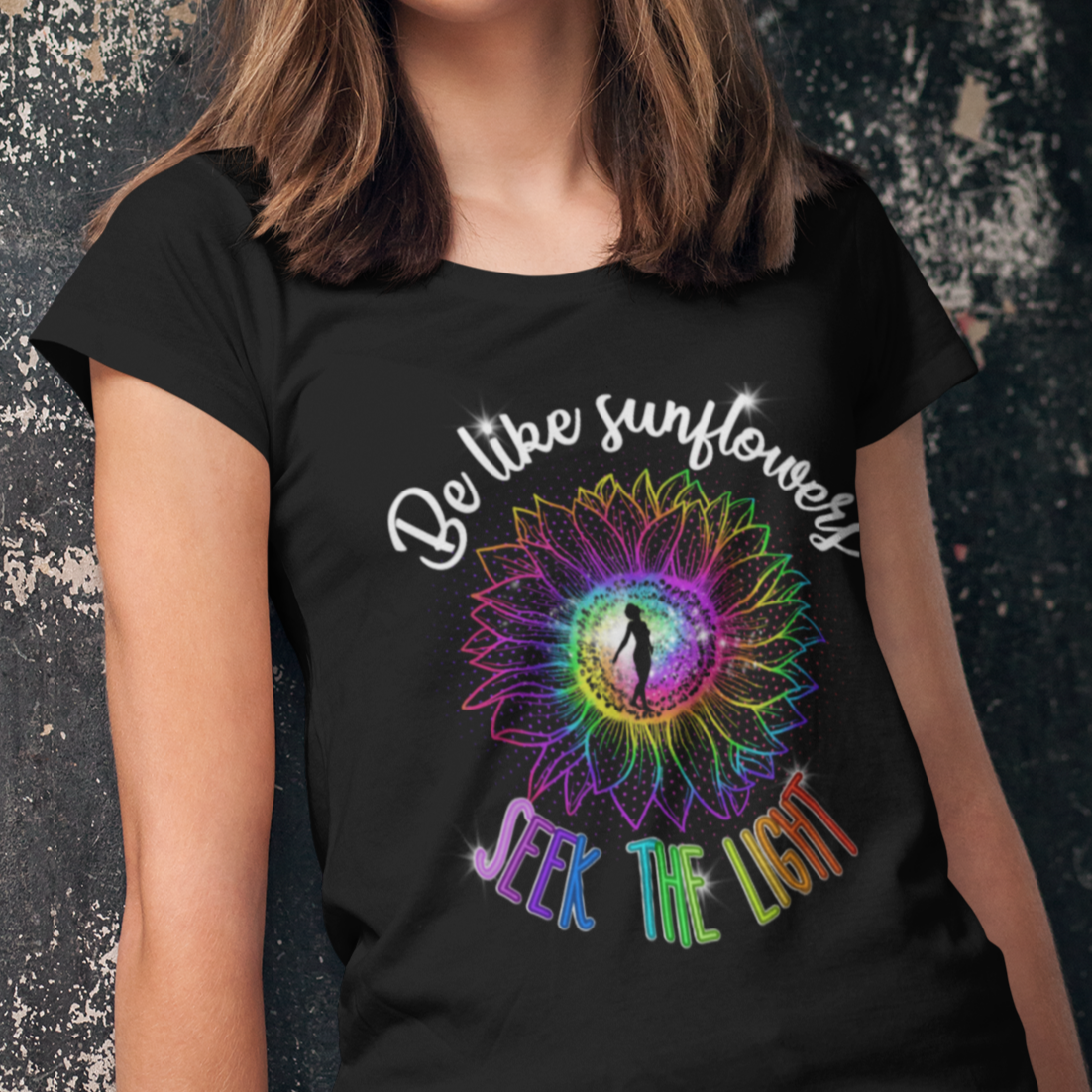Person wearing a black t-shirt with a colorful design and text against a dark textured background