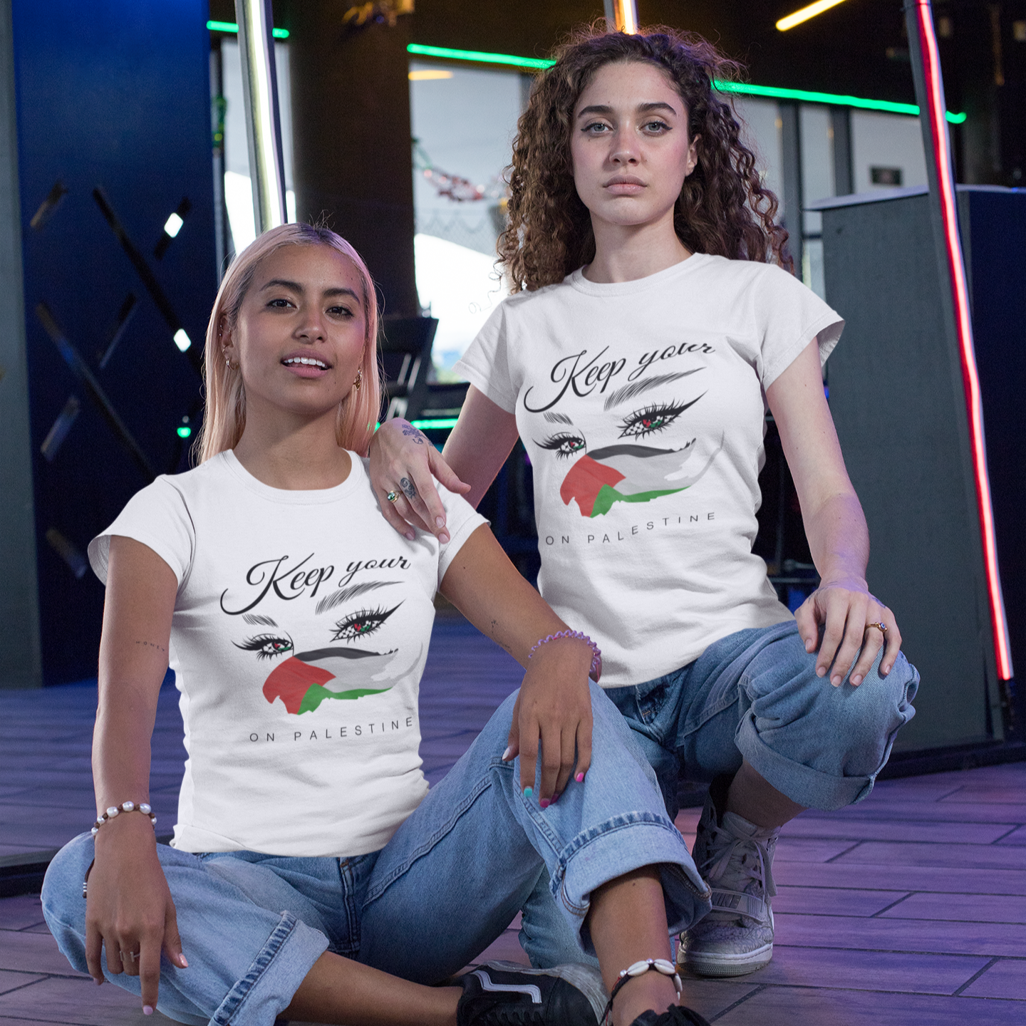Two people wearing white t-shirts with graphic designs in an indoor setting.
