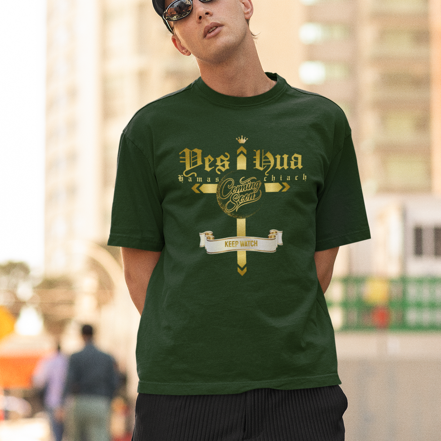 Man wearing a green t-shirt with text and graphics, standing outdoors.