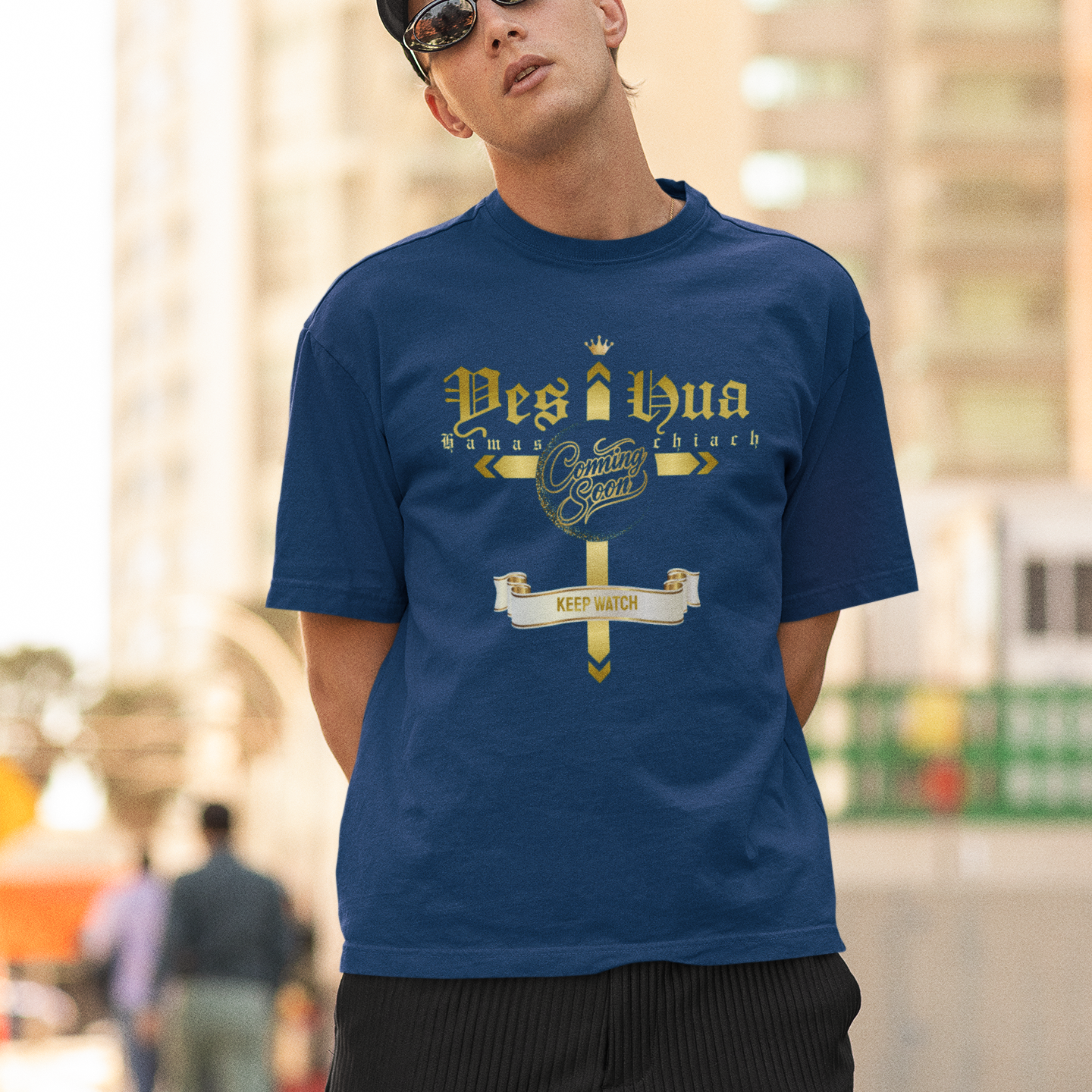 Man wearing a blue t-shirt with text and graphics, standing outdoors.