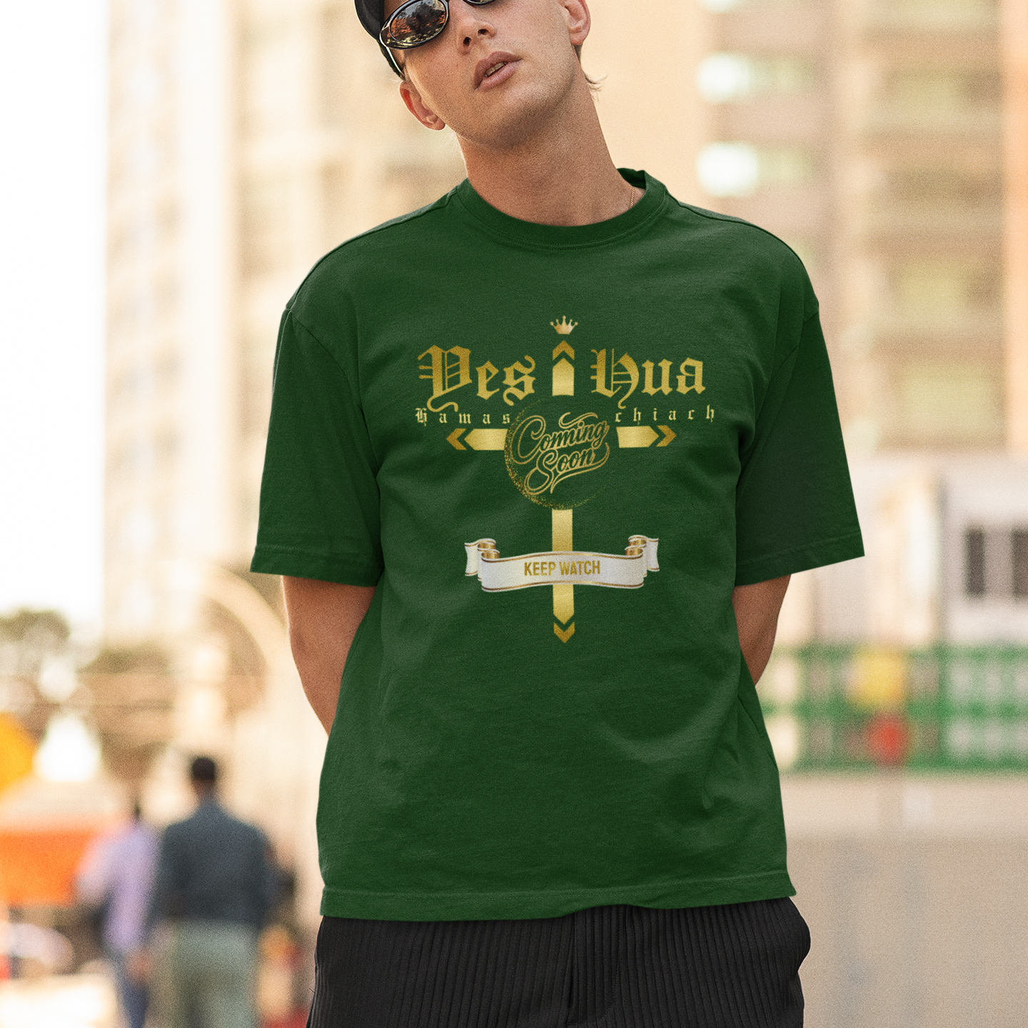 Man wearing a green t-shirt with text and graphics, standing outdoors.