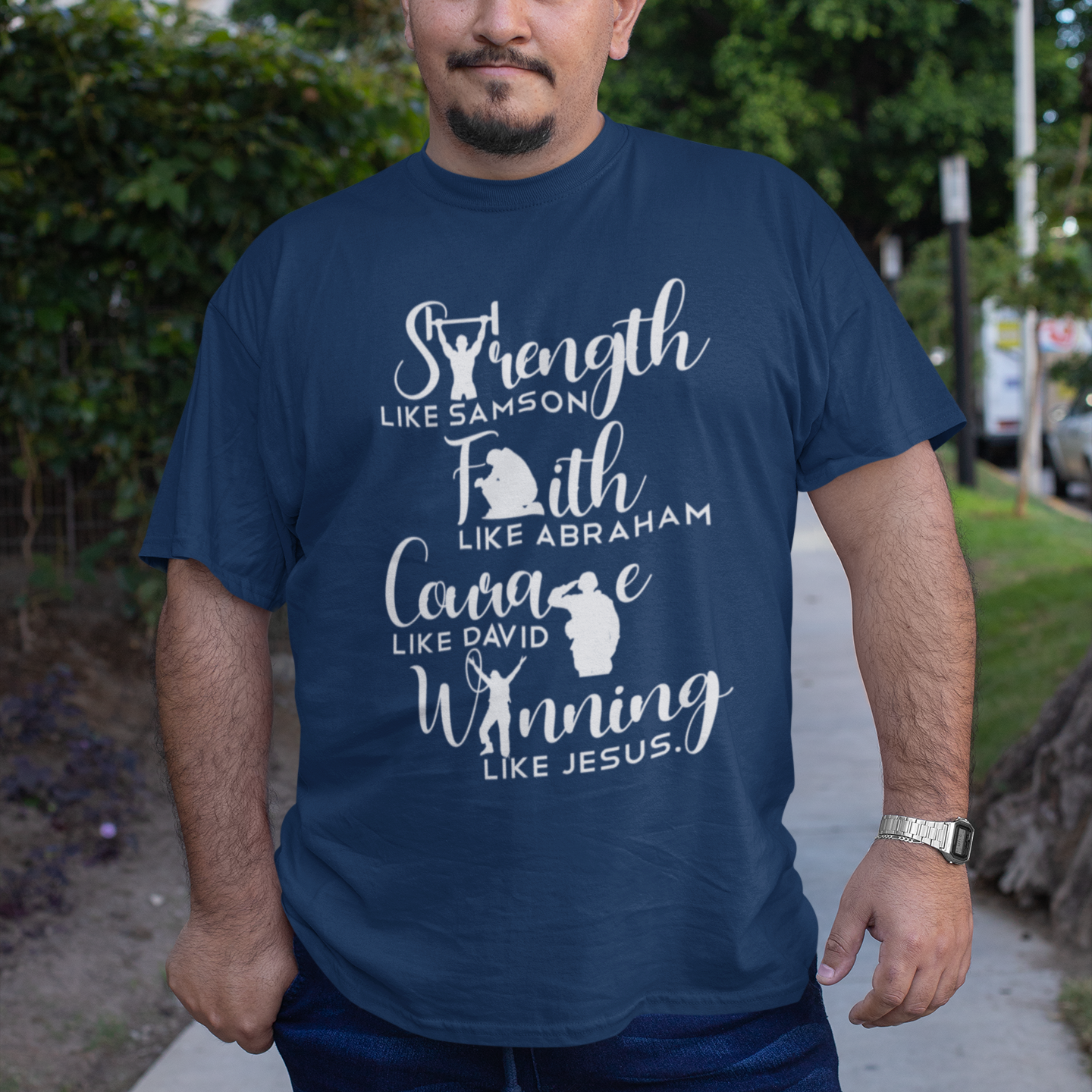 Man wearing a navy blue t-shirt with motivational text and graphics on a sidewalk.