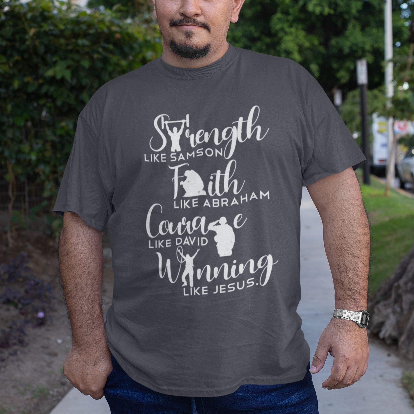 Man wearing a gray t-shirt with motivational text and character illustrations outdoors.