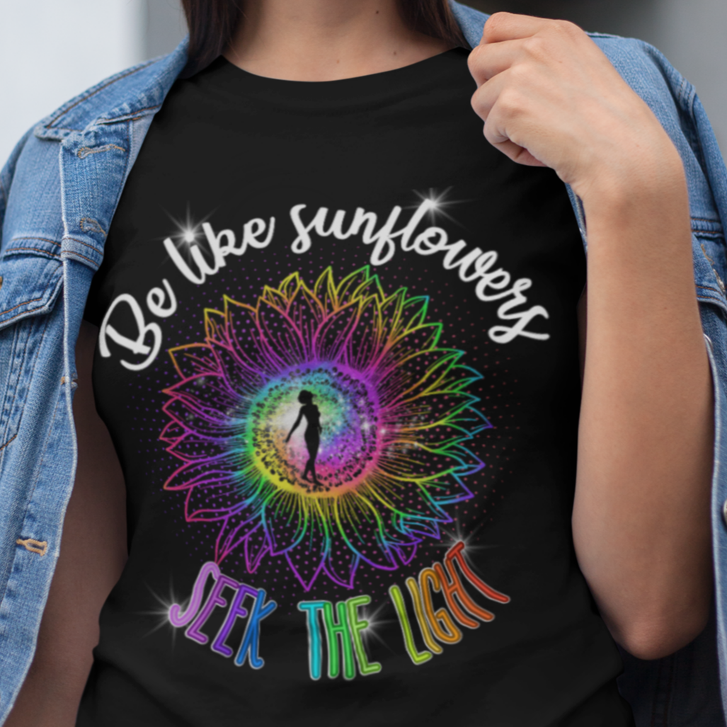 Woman wearing a black t-shirt with colorful design and text outdoors