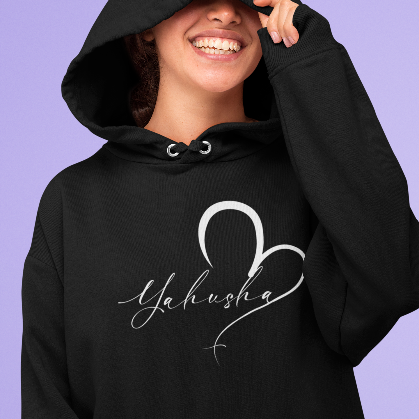 Person wearing a black hoodie with 'Yahusha' design on a purple background
