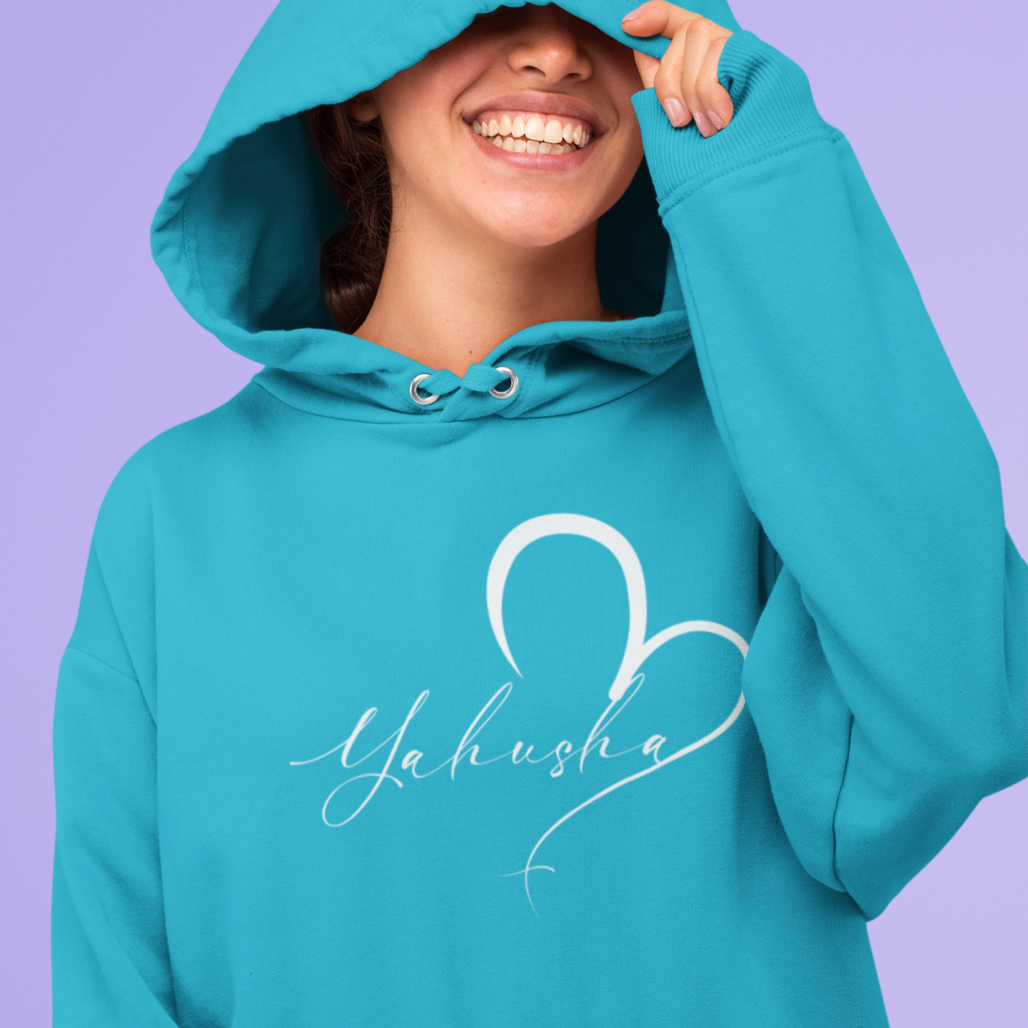 Person wearing a teal hoodie with 'Yahusha' design on a purple background