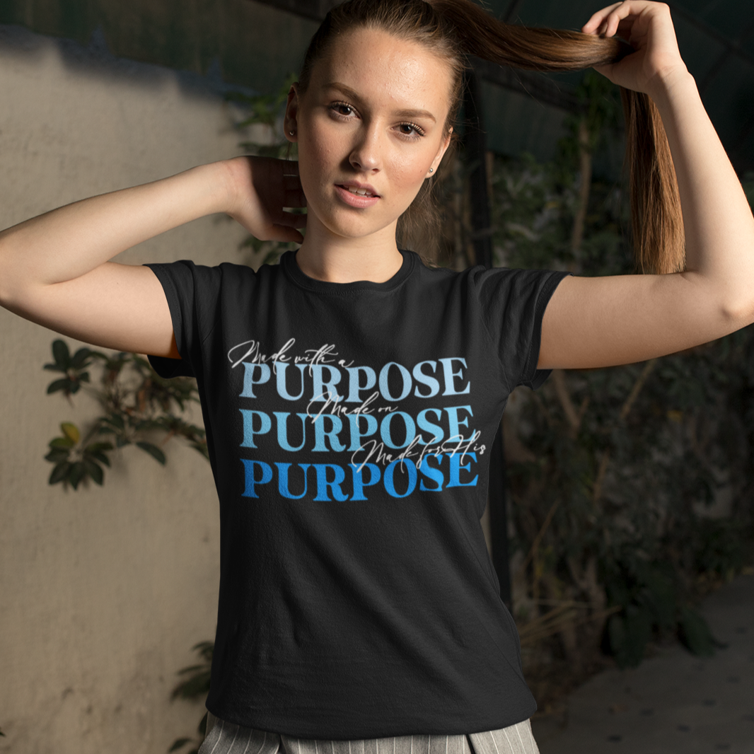 Woman wearing a black t-shirt with text, standing indoors with plants in the background