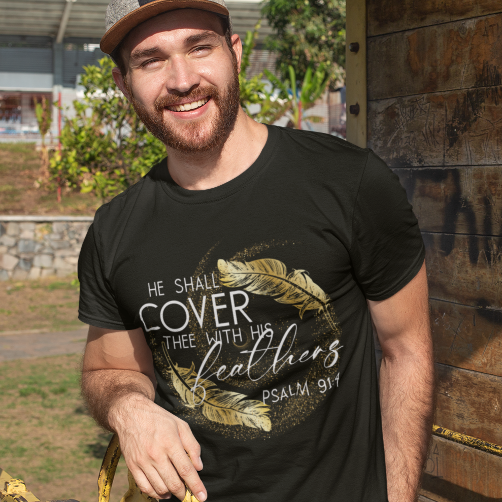 Man wearing a black t-shirt with text and graphics, standing outdoors near a yellow structure.