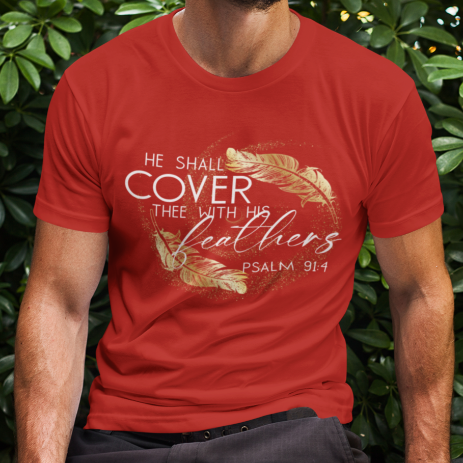 Man wearing a red t-shirt with text and design, sitting outdoors among green bushes.