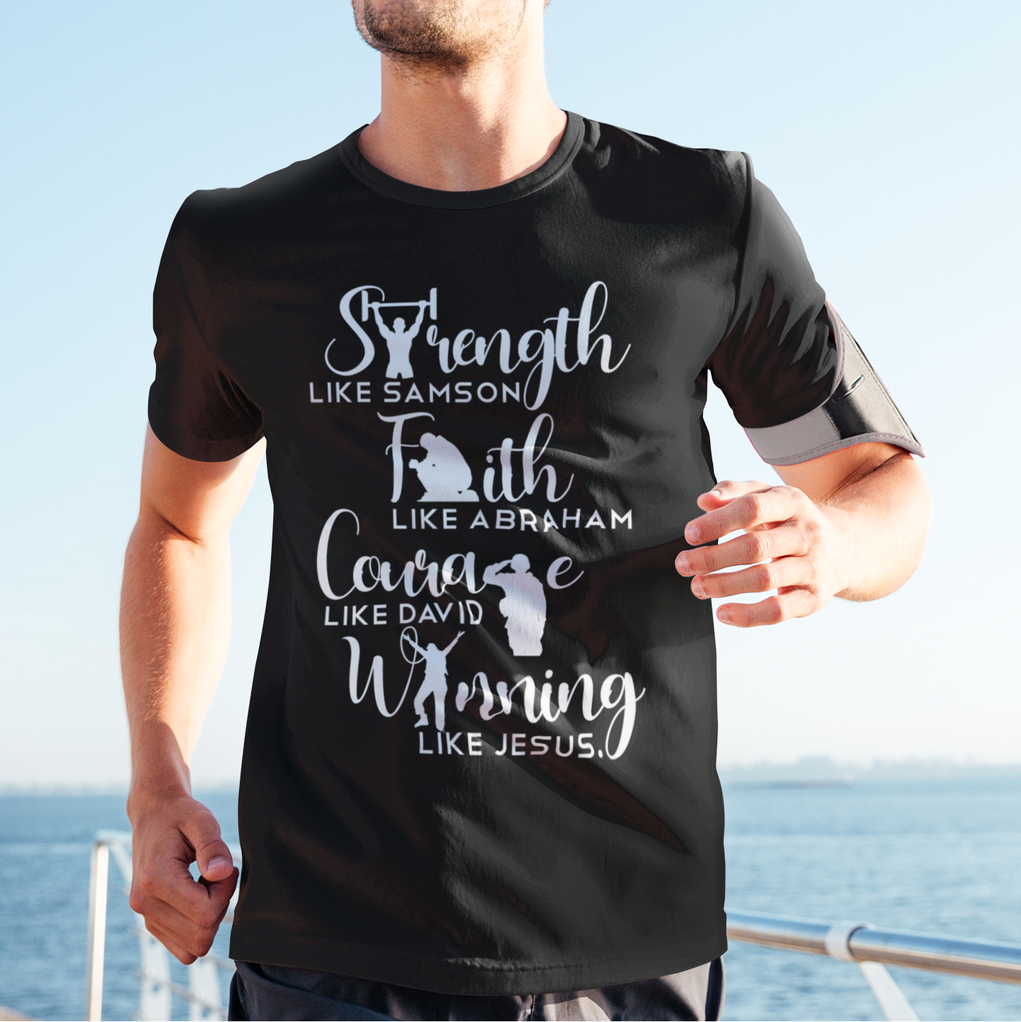 Man wearing a black t-shirt with motivational text by the sea
