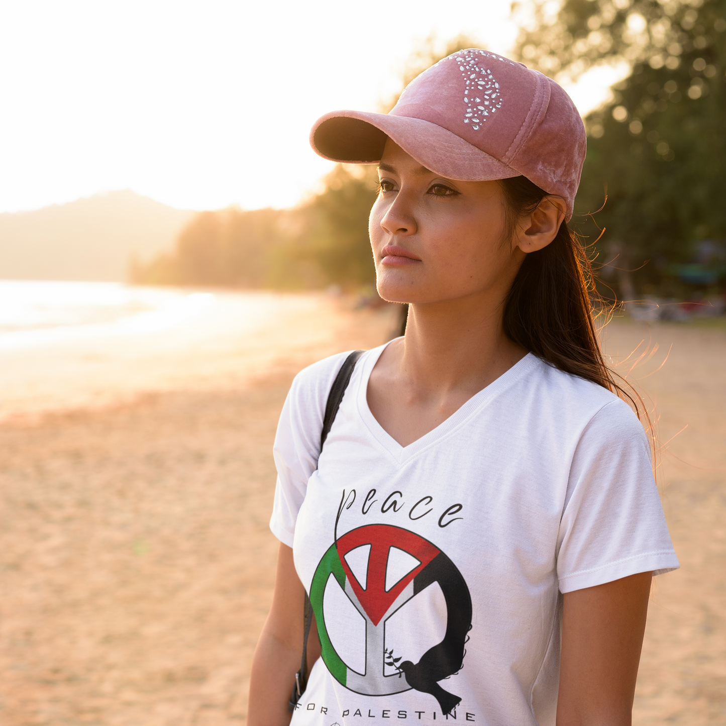 Woman wearing a white t-shirt with a peace symbol design outdoors.