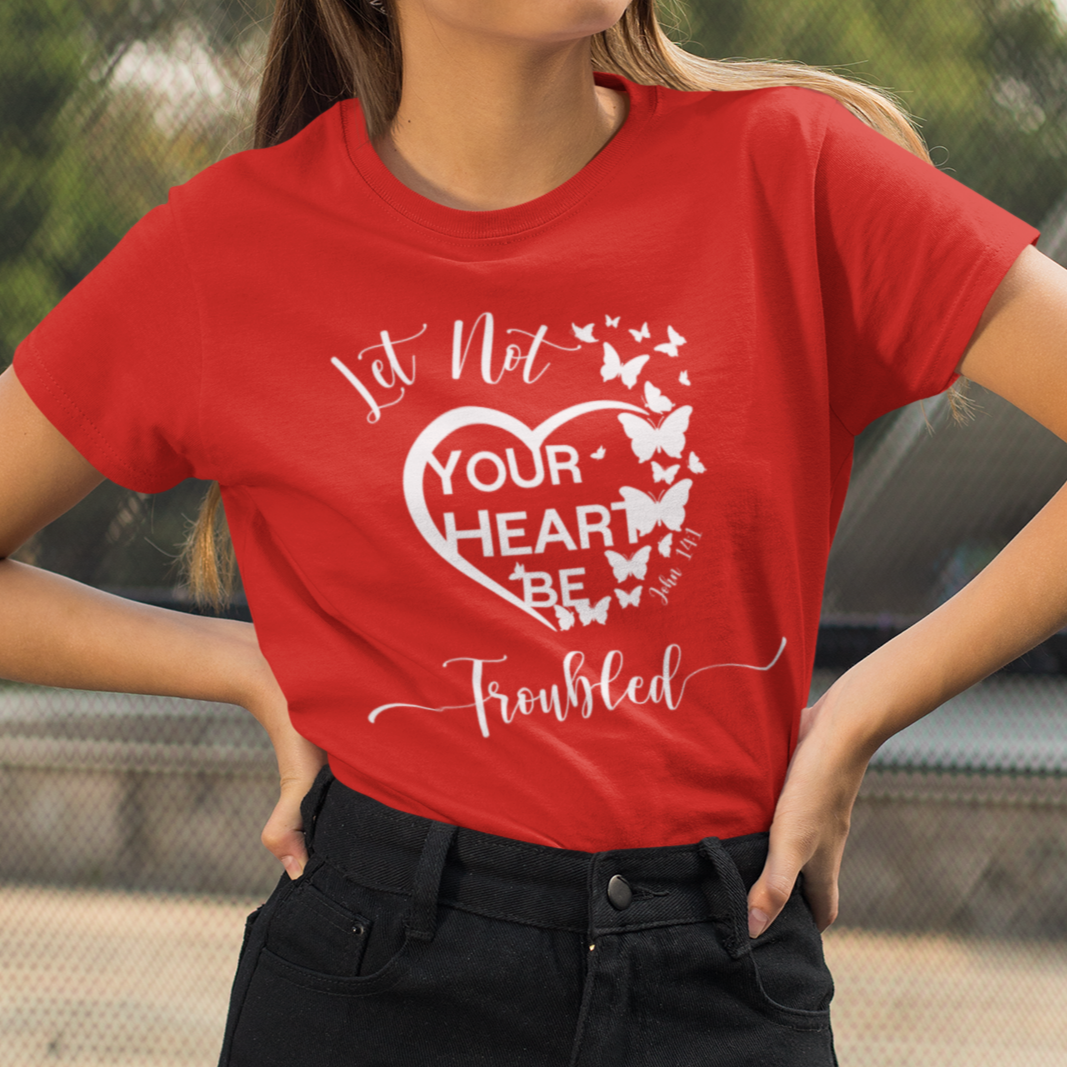 Person wearing a red t-shirt with a printed design outdoors.