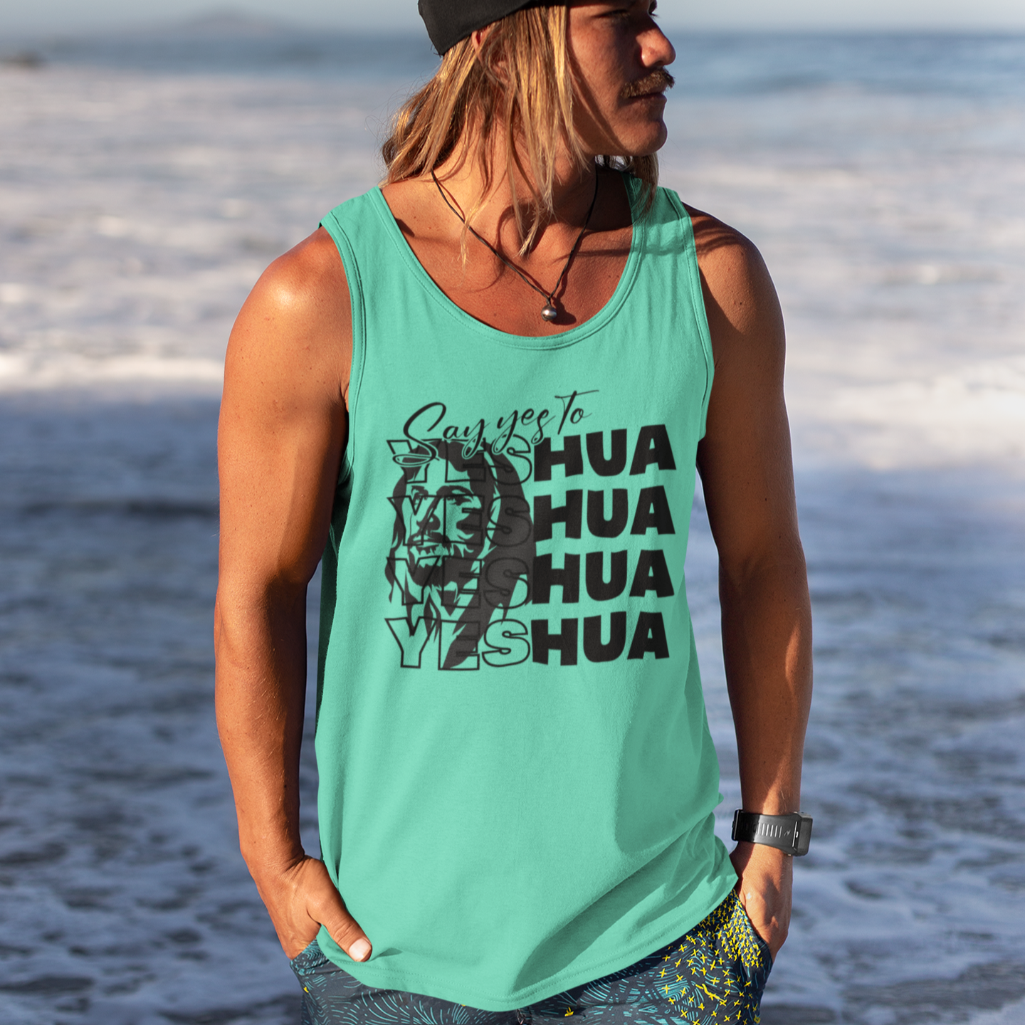 Person wearing a green tank top with text and graphics on a beach